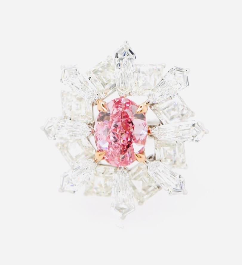 Emilio Jewelry, un grossiste/détaillant bien connu et respecté situé sur l'emblématique Cinquième Avenue de New York,
Le point focal de cette bague est le diamant ovale rose vif certifié GIA, de qualité investissement, serti au centre. Le diamant