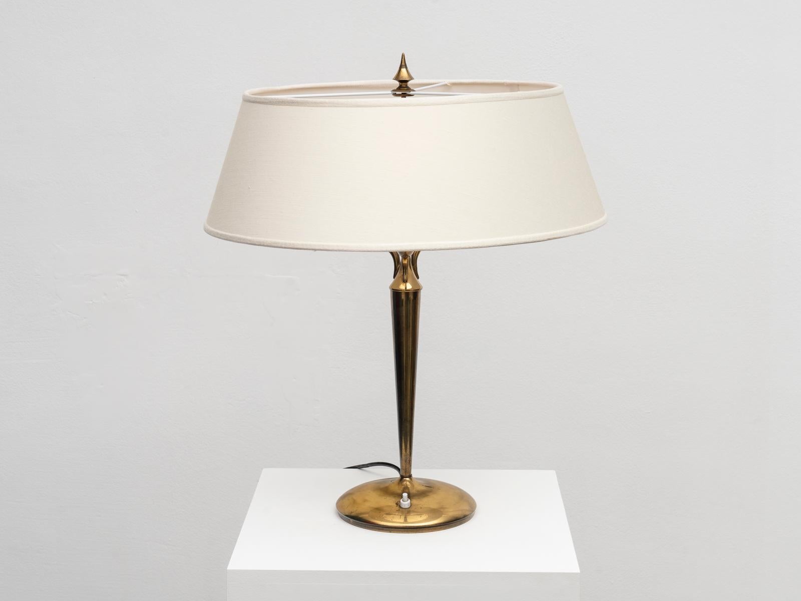 This table lamp was designed in the 1940s by the Italian architect Emilio Lancia, a peer of Gio Ponti with whom he worked on several projects.
This tall three-armed table lamp was manufactured in solid brass. The fabric lampshade is newly made. The