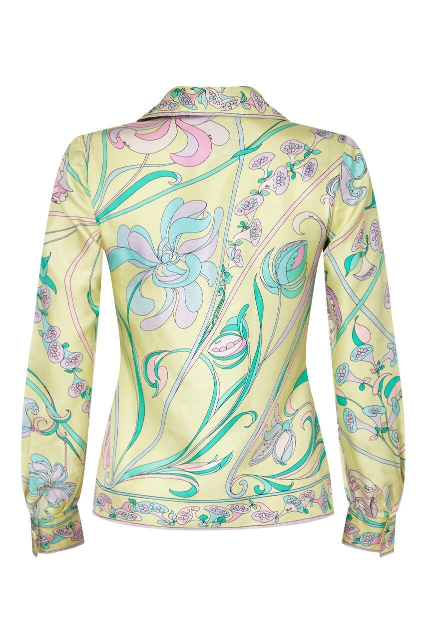 This late 1960s pastel toned silk blouse by Emilio Pucci is feminine, chic and in lovely vintage condition. The soft silk fabric has a abstracted floral design synonymous with its creator in soft shades of lemon, sugar pink, jade green and lilac. As