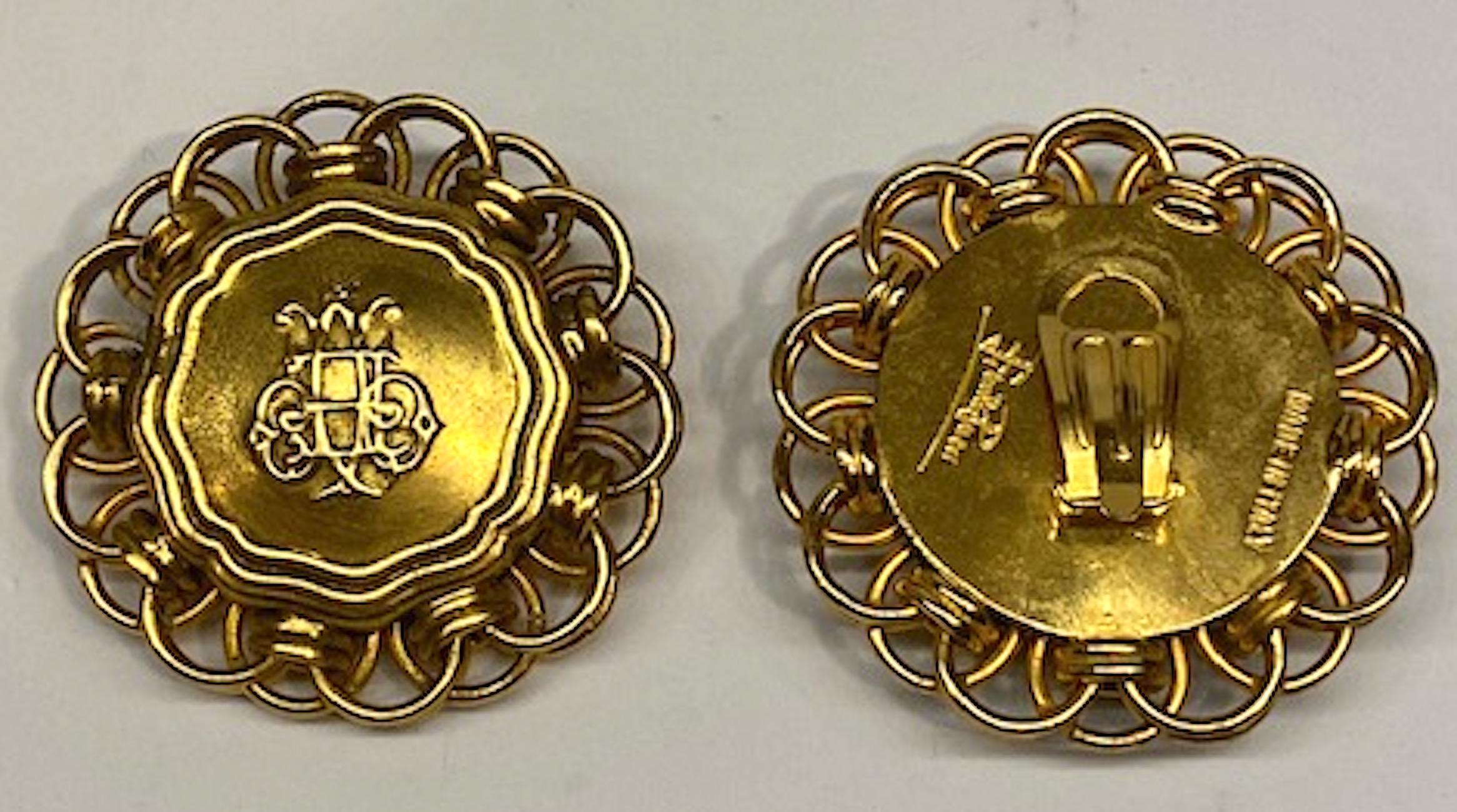 A large pair of 1980s statement satin gold tone button earrings by iconic fashion house Emilio Pucci. Each earring measures 2 inches in diameter. The front button measures 0.38 deep. Central medallion has a scrip combination of the letters E and P