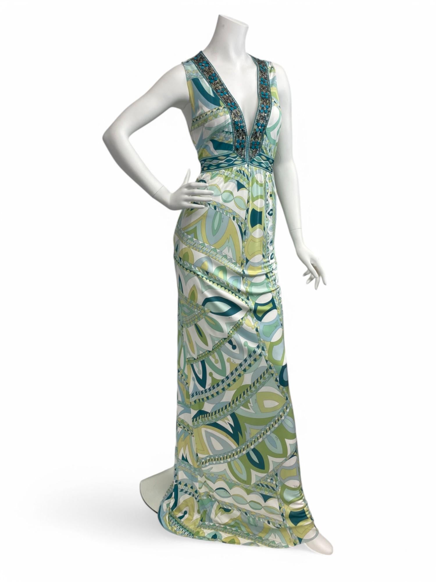 A vibrant and fluid statement piece, this Emilio Pucci maxi dress showcases the house’s signature multicolor abstract print in bold shades of green and blue. The design features a flattering V-neckline and is intricately embellished with tonal