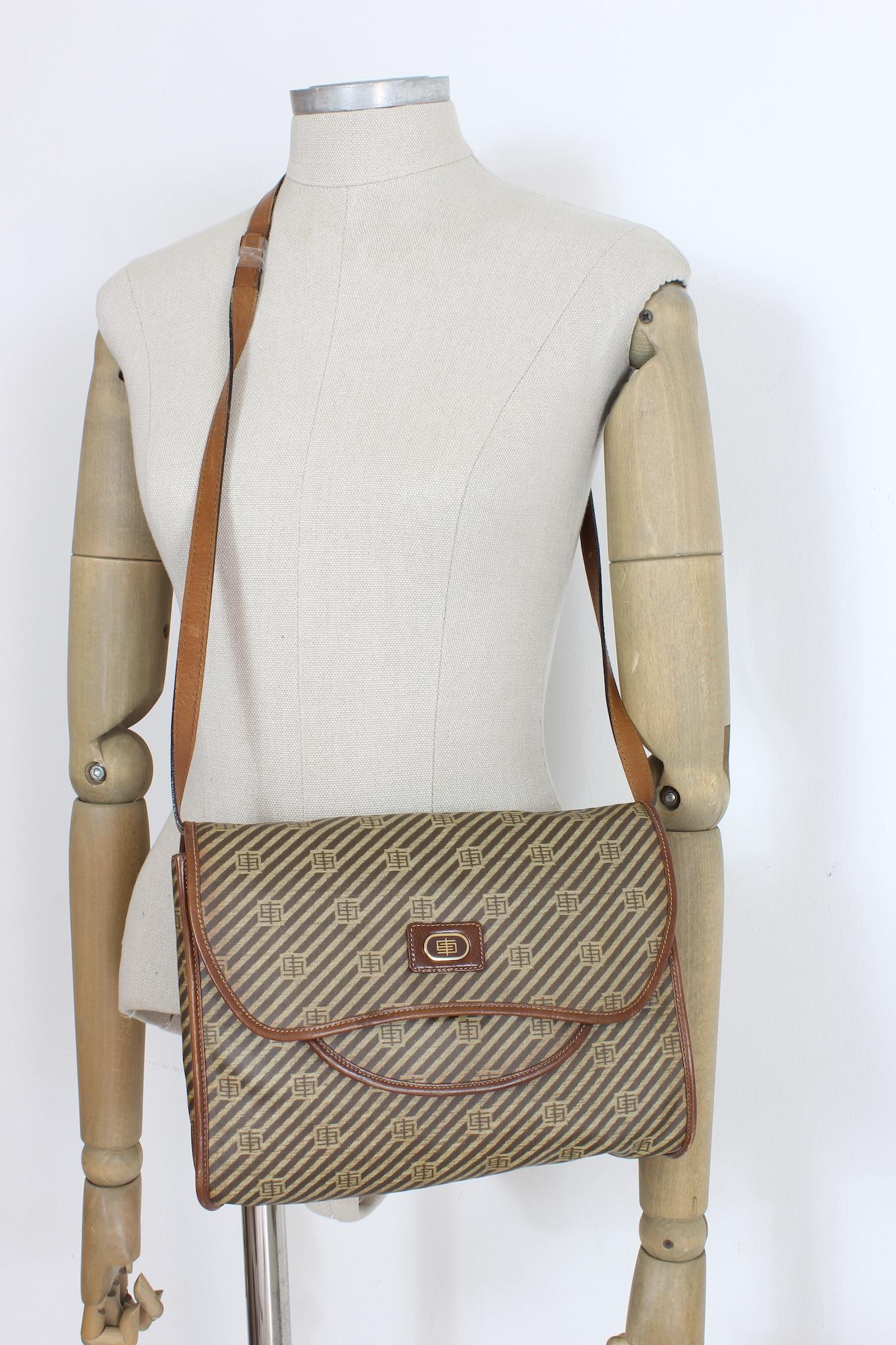 Emilio Pucci vintage shoulder bag from the 80s. Leather and canvas fabric, beige and brown monogram pattern. Adjustable shoulder strap, gold-colored metal details. Inside pockets on both sides, outside there is a zip pocket. Made in Italy.

Code: