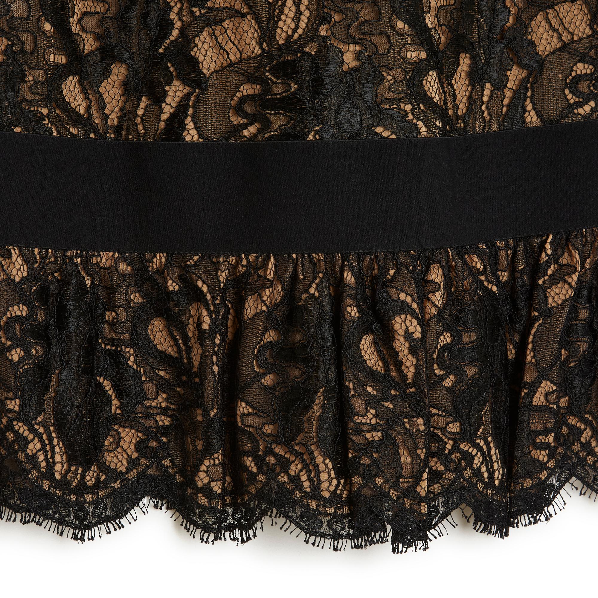 Emilio Pucci skirt in black viscose lace, straight cut decorated with a low ruffle, all mounted on flesh-colored silk crepe, high waist on a wide black elastic ribbon, fastening with a long zip on the side. Size 42FR (better in 40FR): waist 39 cm,