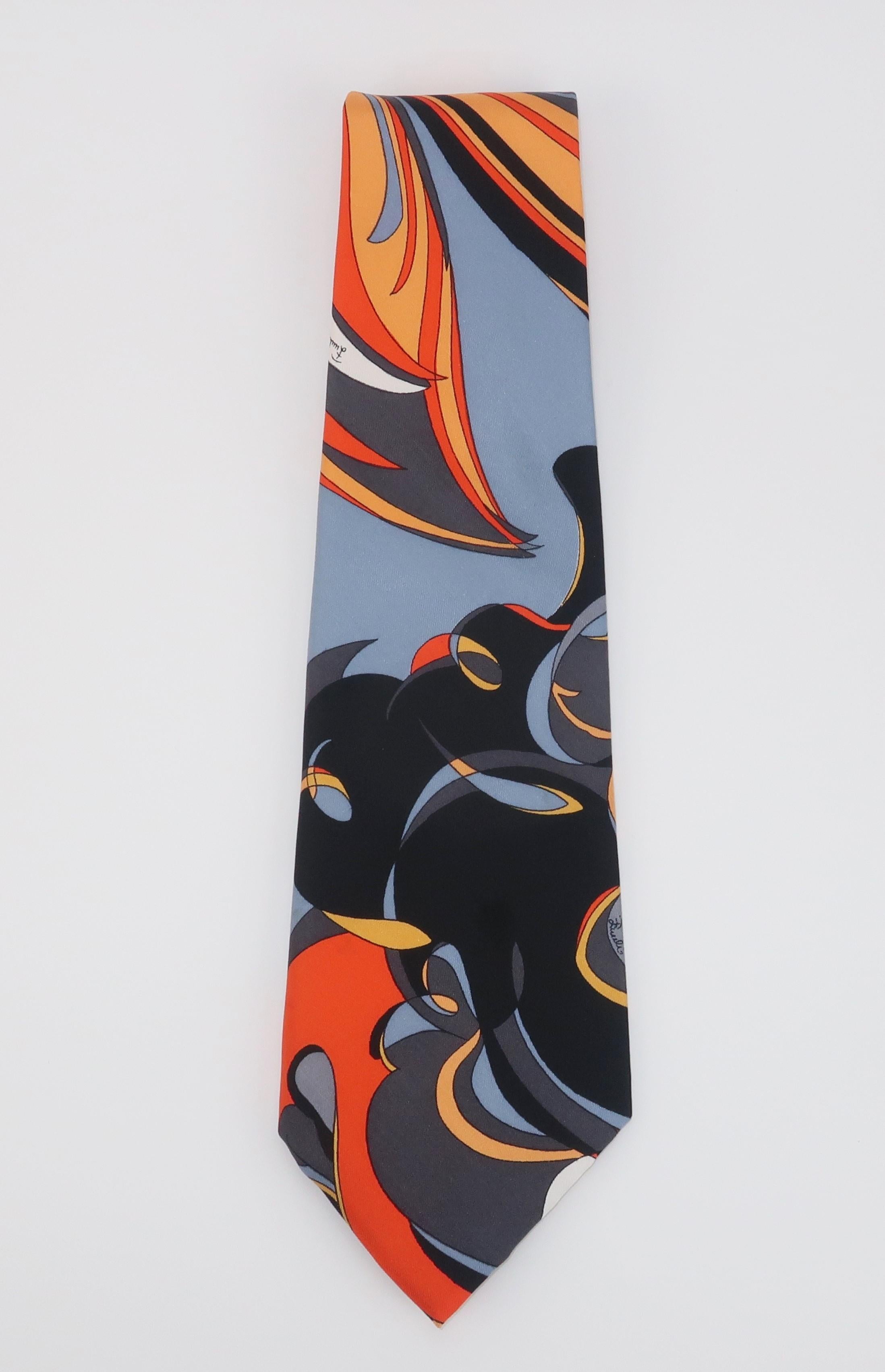 1970's Emilio Pucci silk neck tie in shades of orange, gray and black.  The Emilio Pucci name appears in the psychedelic design and the silk liner is embossed with the logo, as well.  It has a great mod look that is perfect for adding a Pucci style