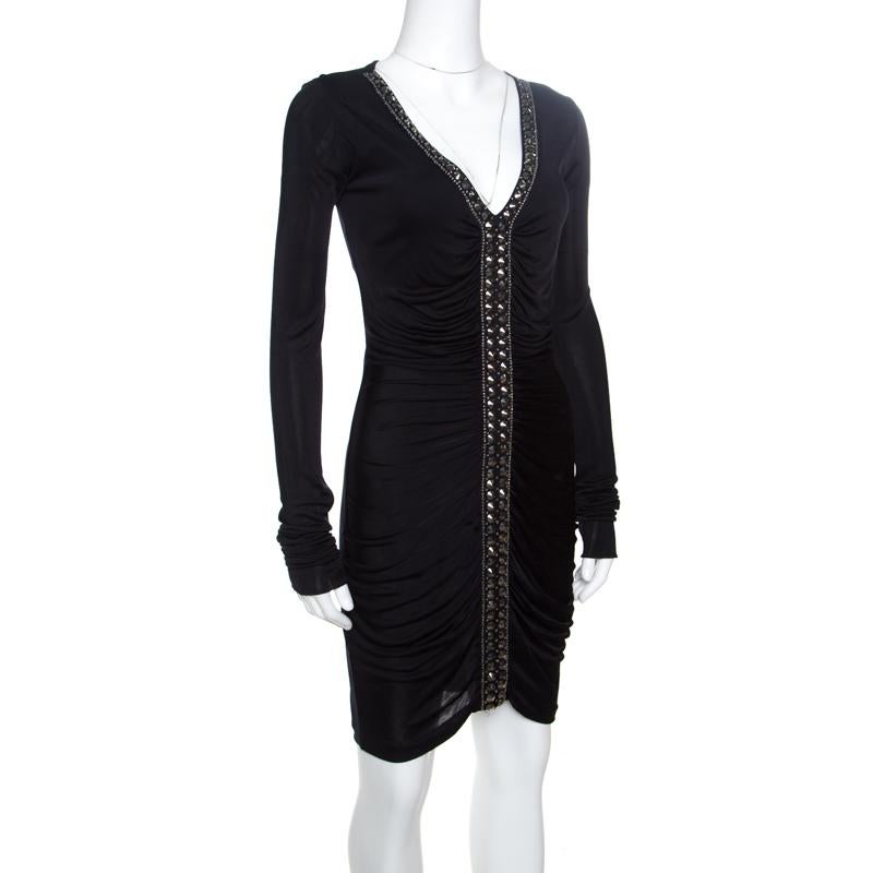 This dress from Emilio Pucci will sweetly complement your elegant style statement. Featuring a ruched pattern, the dress has long sleeves and shimmery rhinestone embellishments on the front. It is adorned in a classic black hue and exudes a gleaming