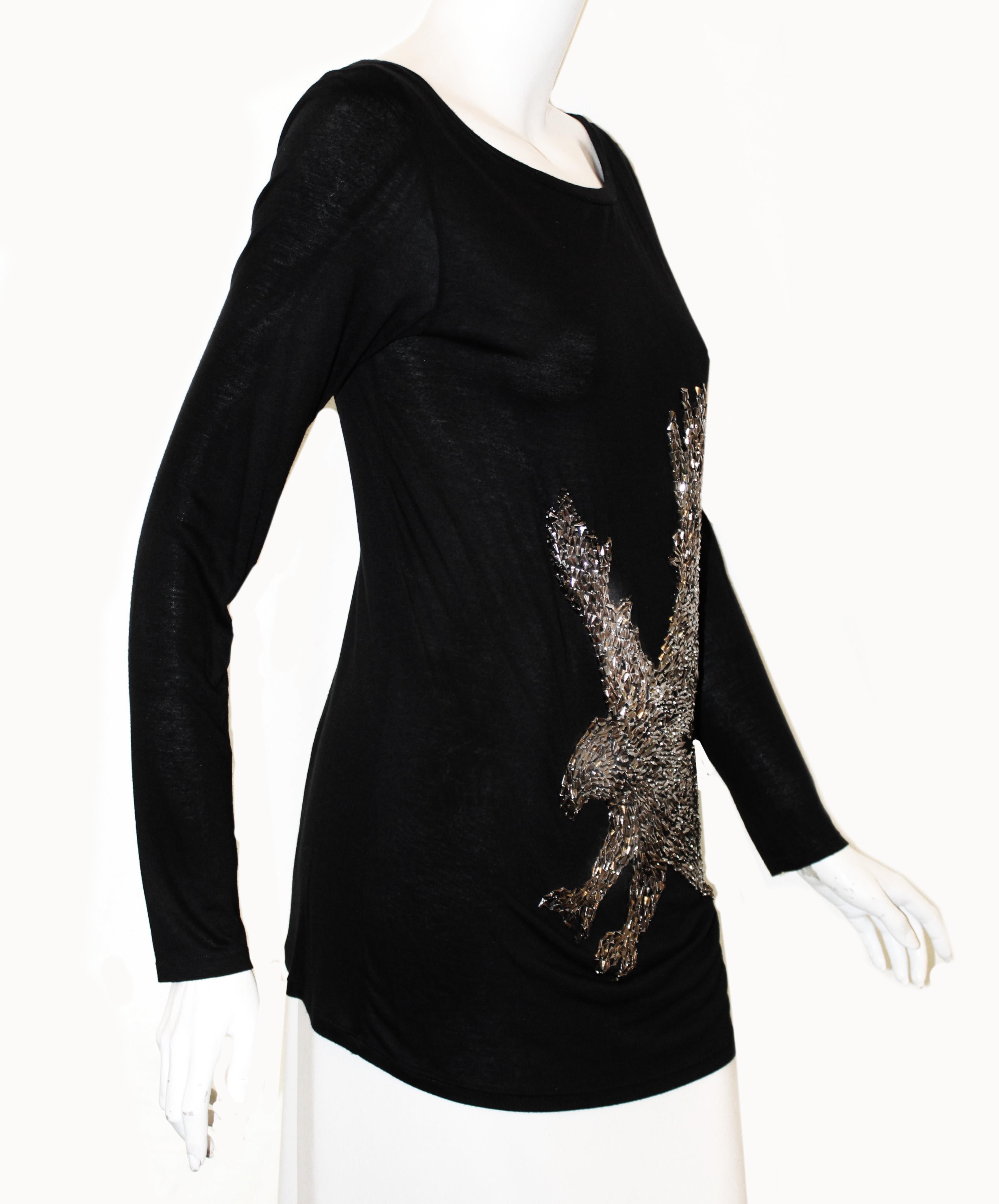 Emilio Pucci black long sleeve bateau neckline has dressed up with an outstanding handmade sculpture of a flying eagle design.  Using pewter tone metal studs the soaring eagle is ready to catch his prey!   This top is not lined and is in excellent