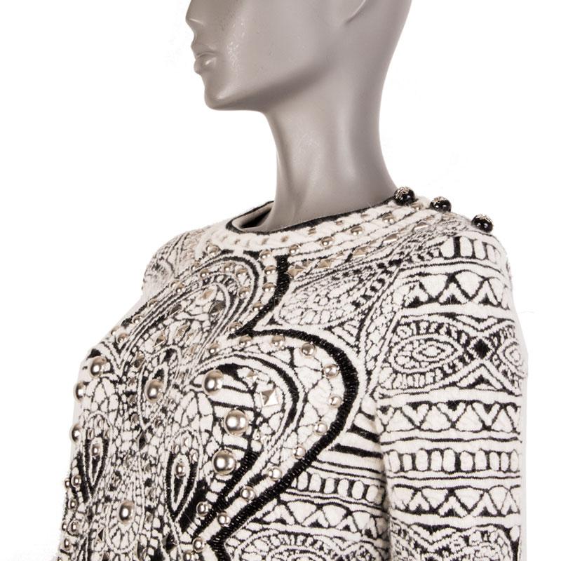 
100% authentic Emilio Pucci studded knit sweater in off-white and black angora (42%), wool (41%) and polyamide (17%). With crew neck, silver studs and black bead applications, and three decorative crest ball buttons in black and silver acetate on