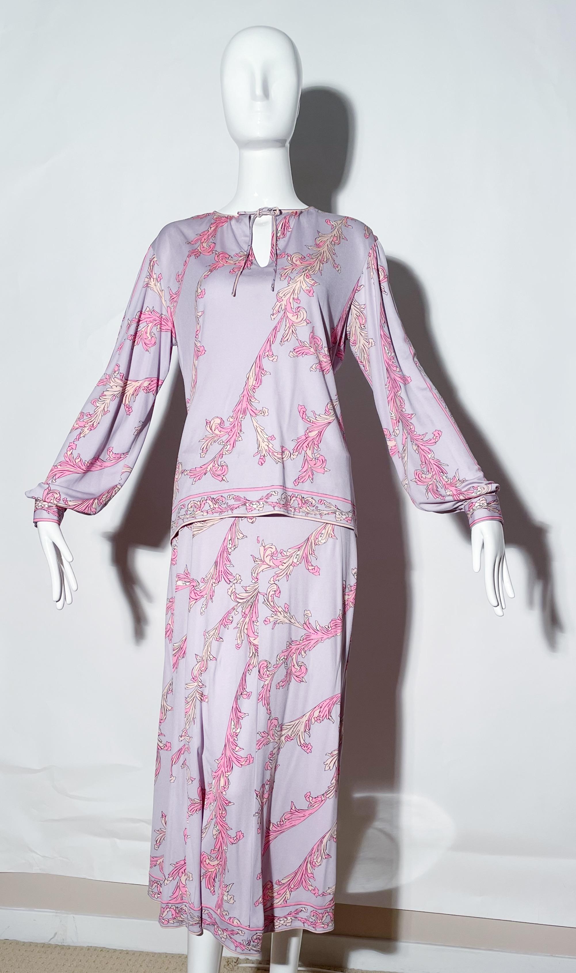 Purple and pink printed skirt and blouse set. Front tie at neckline. Rear zipper on skirt. Silk. Made in Italy. 
*Condition: Excellent vintage condition. No visible Flaws.

Measurements Taken Laying Flat (inches)—
Shoulder to Shoulder: 17 in.
Sleeve