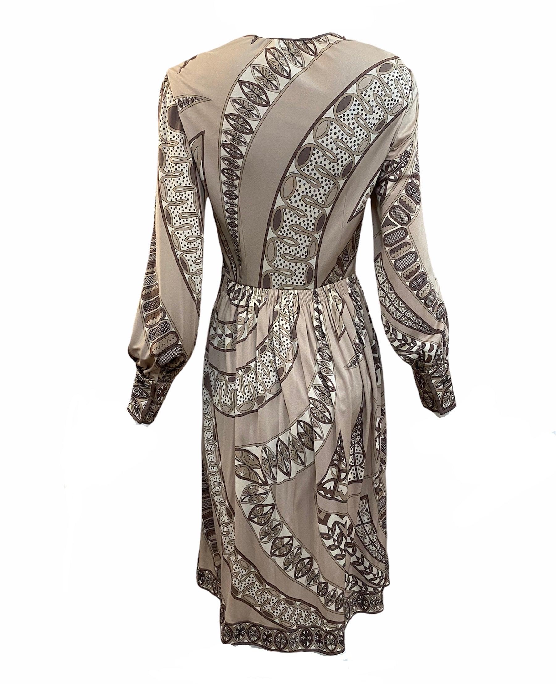 A true classic. 1970s era dress from Emilio Pucci. In silk jersey in tones of brown and beige with wild iconic print that makes this dress immediately recognizable. Fully lined and lightweight.  Hand pleated at waist. Ties at neck and zips up side.