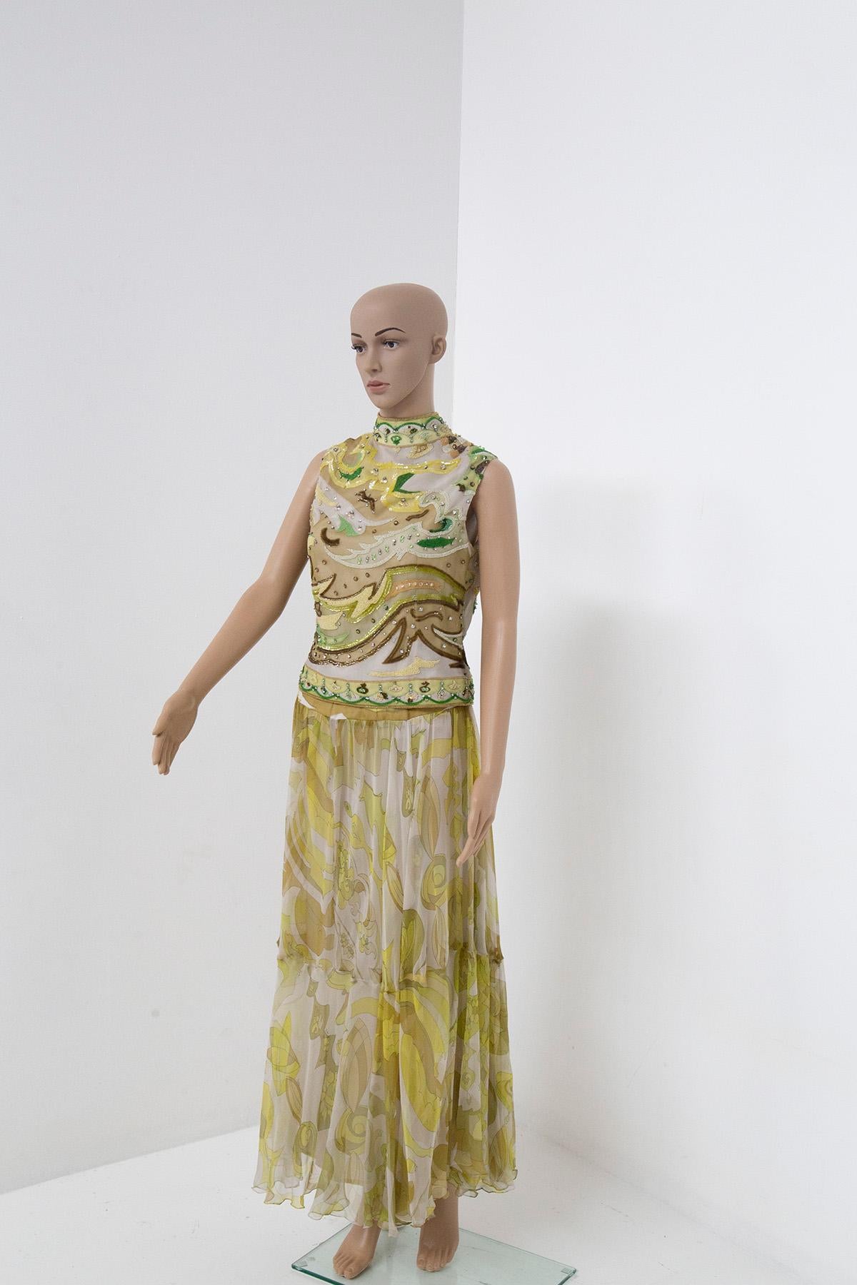 In a world of timeless elegance and vintage allure, there exists a remarkable Emilio Pucci two-piece evening dress that stands as a testament to the designer's unparalleled artistry. With shades of yellow and green that evoke the vibrant hues of a