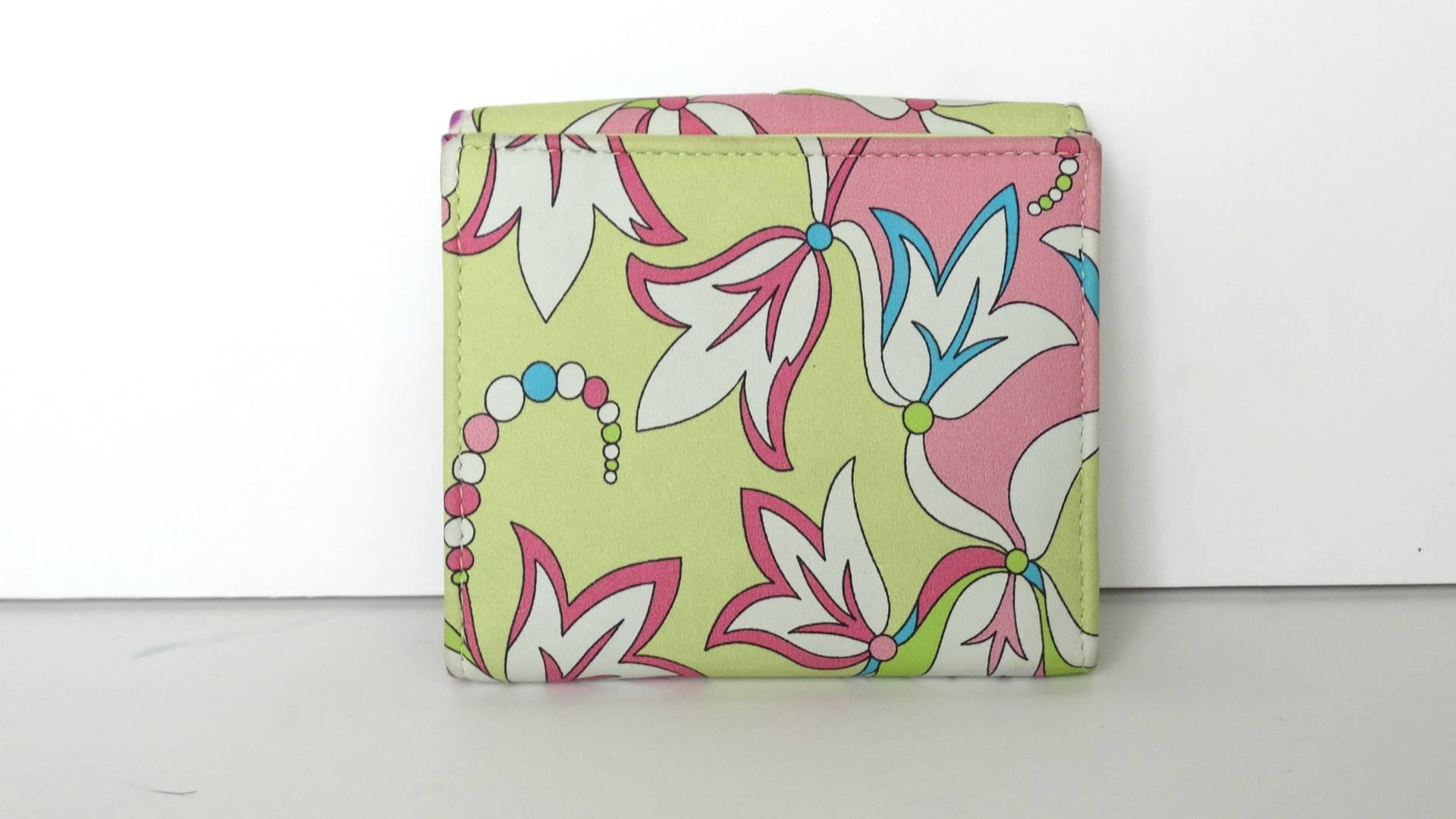 Where loving this color combo and print on this early 2000's Pucci wallet. This wallet allows you to carry plenty plastic, coins and cash.Wallet colors are soft hues of lime green, pink and blue. Interior of the wallet is in a soft butter leather. 