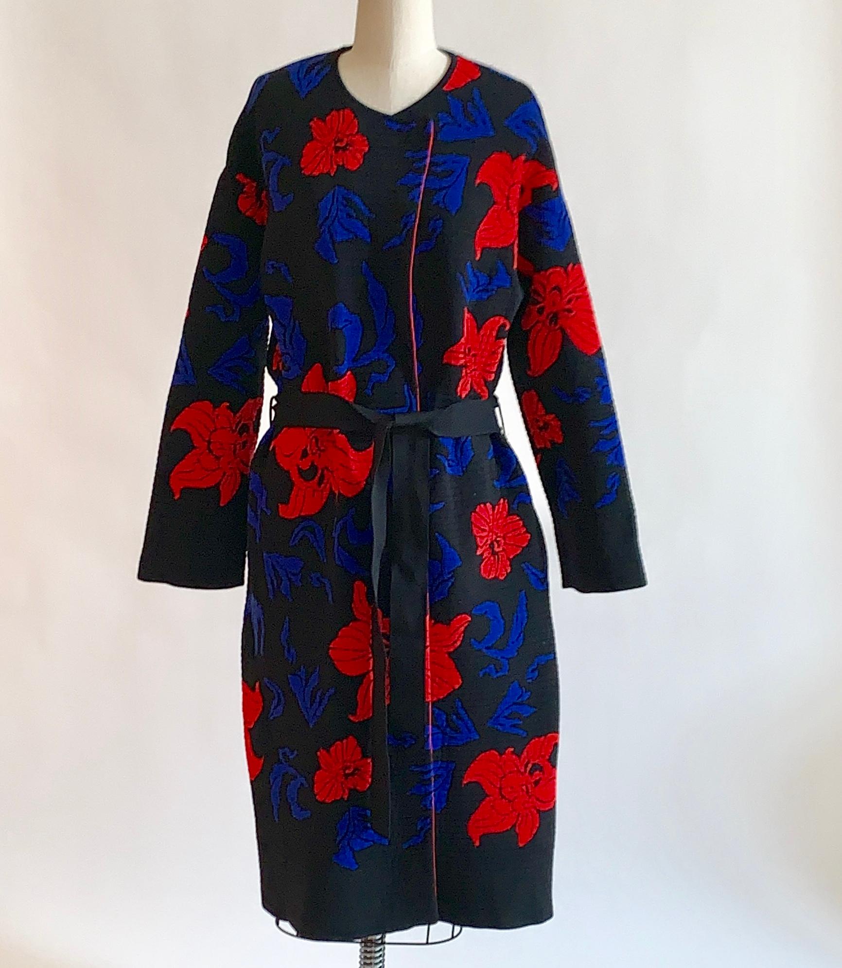 Emilio Pucci black rib knit mid-weight sweater coat with red and blue flower print throughout. Fastens with two snaps at neck and tie belt at waist. Could also be styled for indoor wear as a duster cardigan. 

100% nylon/polyamide.

Made in Italy.