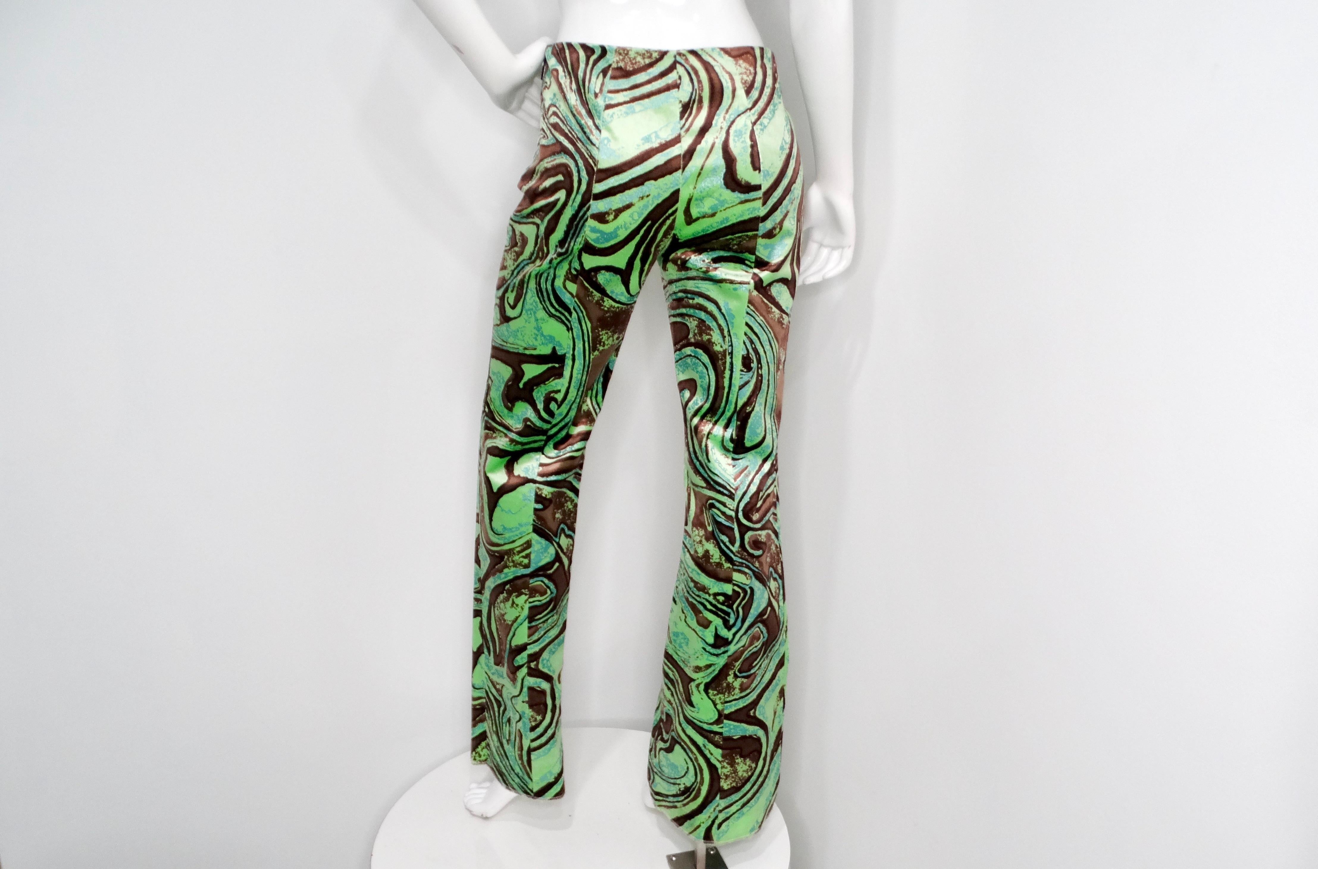 Le pantalon en velours imprimé abstrait vert et marron d'Emilio Pucci est une pièce luxueuse qui allie sans effort confort et style. Doté d'une taille haute, ce pantalon arbore un imprimé exquis de style Pucci caractérisé par des teintes vertes et
