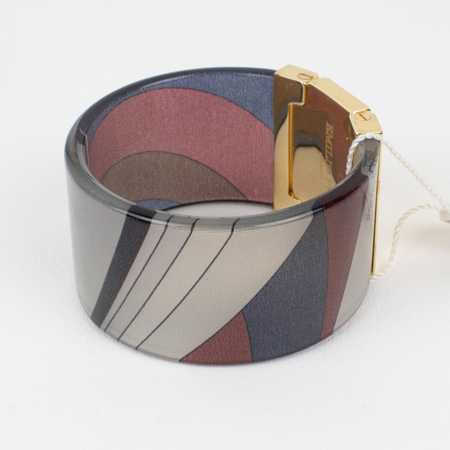 Superb chunky Emilio Pucci gilded metal, acrylic, and silk bracelet bangle. Large bangle shape of a clear acrylic band with multicolor Pucci silk inclusion. The bracelet is ornate with a gilt metal faux hinge topped with a massive rectangular
