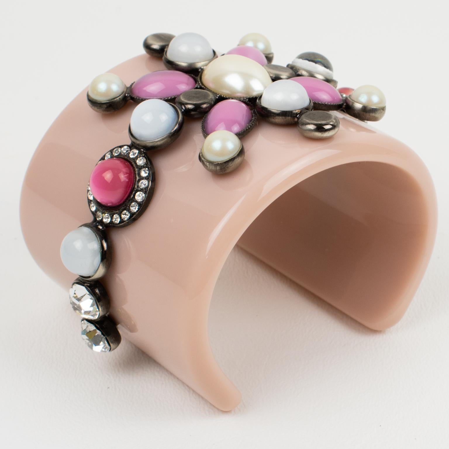 Emilio Pucci designed this adorable massive resin baroque bracelet bangle. The chunky cuff is made of pale pink resin ornate with a gunmetal framing geometric design topped with poured glass cabochons and crystal rhinestones. The jewel design has