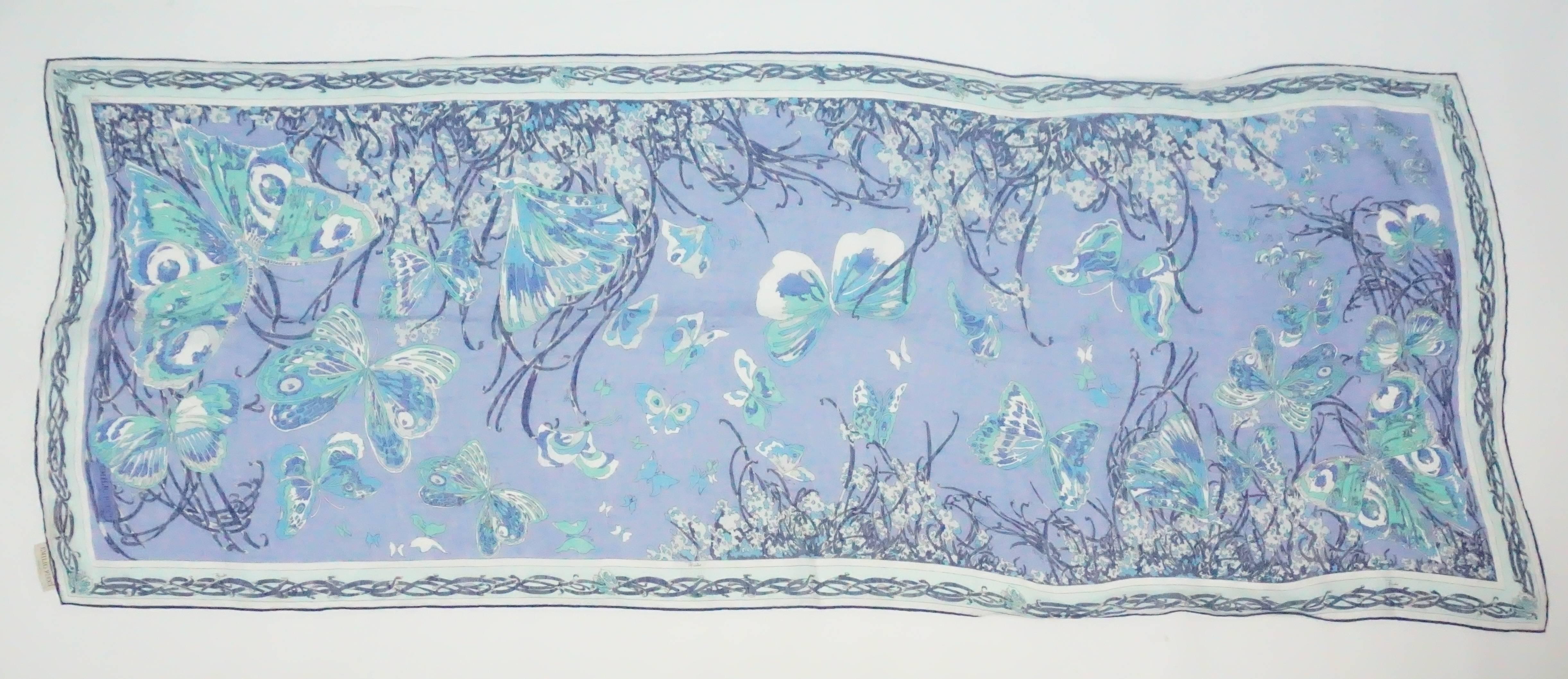 Emilio Pucci Blue Print Cotton Shawl  This Pucci cotton large scarf/shawl is made up of different shades of blues. There are butterfly shapes throughout the scarf and a boarder that contains a design of woven lines. This item is in good vintage