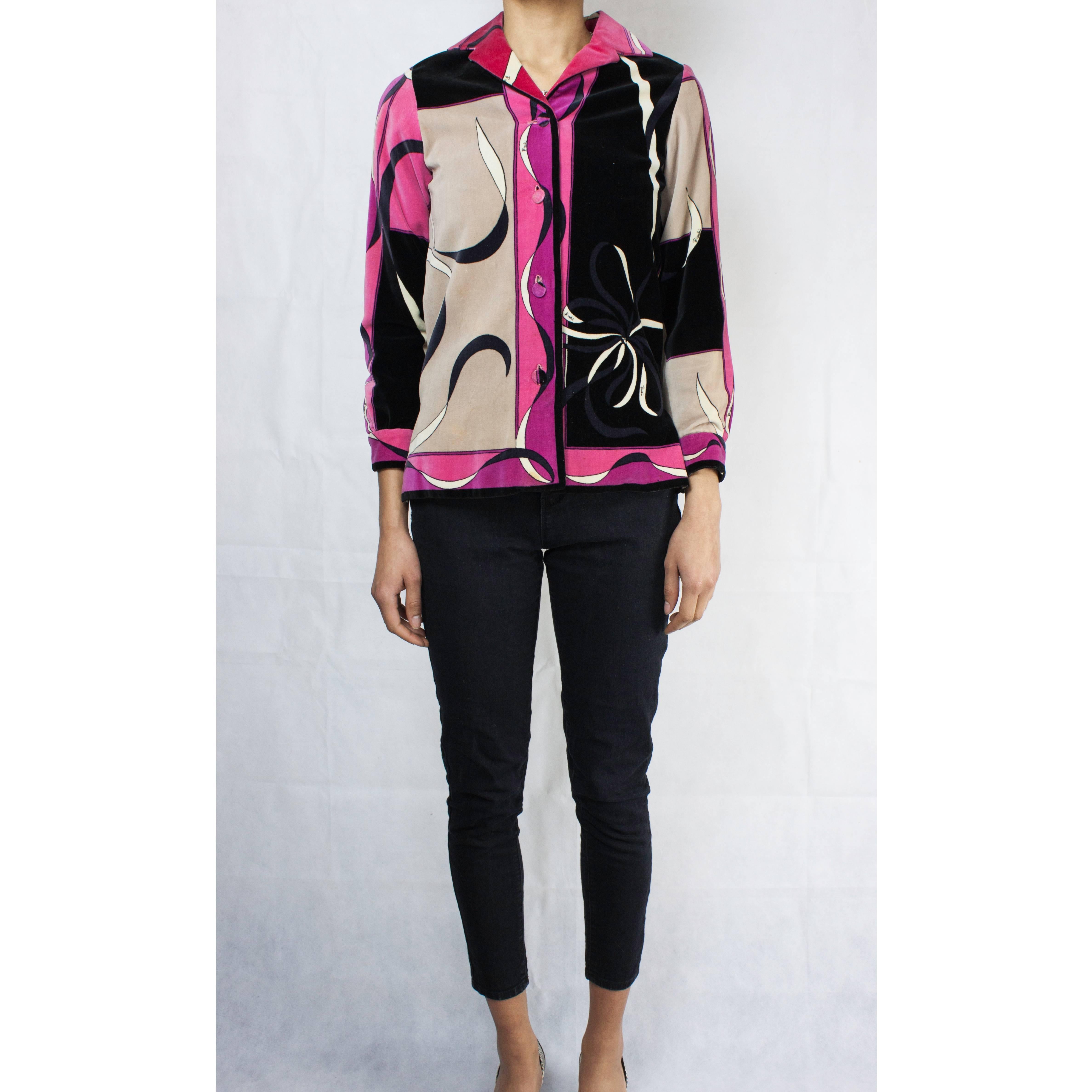 Cette veste Emilio Pucci ancienne est réalisée en velours de coton dans les tons de fuchsia, rose, noir ,  couleurs sable et blanc. Il présente un revers cranté. Fermeture avec quatre boutons en velours sur le devant et des boutons simples aux