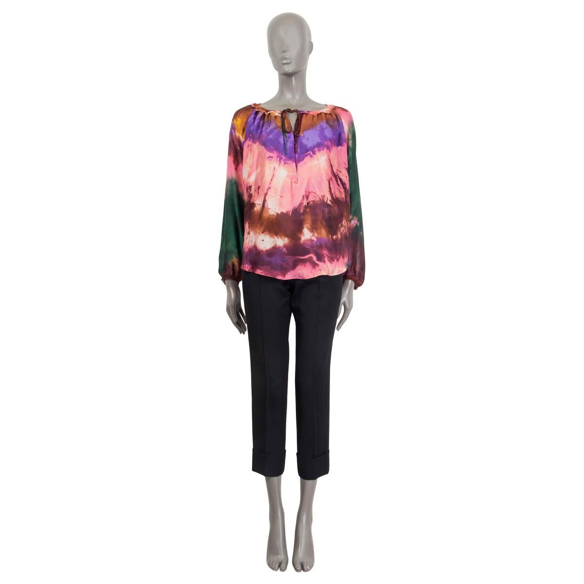 100% authentic Emilio Pucci tie-dye blouse in brown, green, pink, purple and curry silk (100%). Features long raglan (sleeve measurements taken from the neck) balloon sleeves and a rushed, fringed hem. Opens with a hook and a self-tie ribbon at the