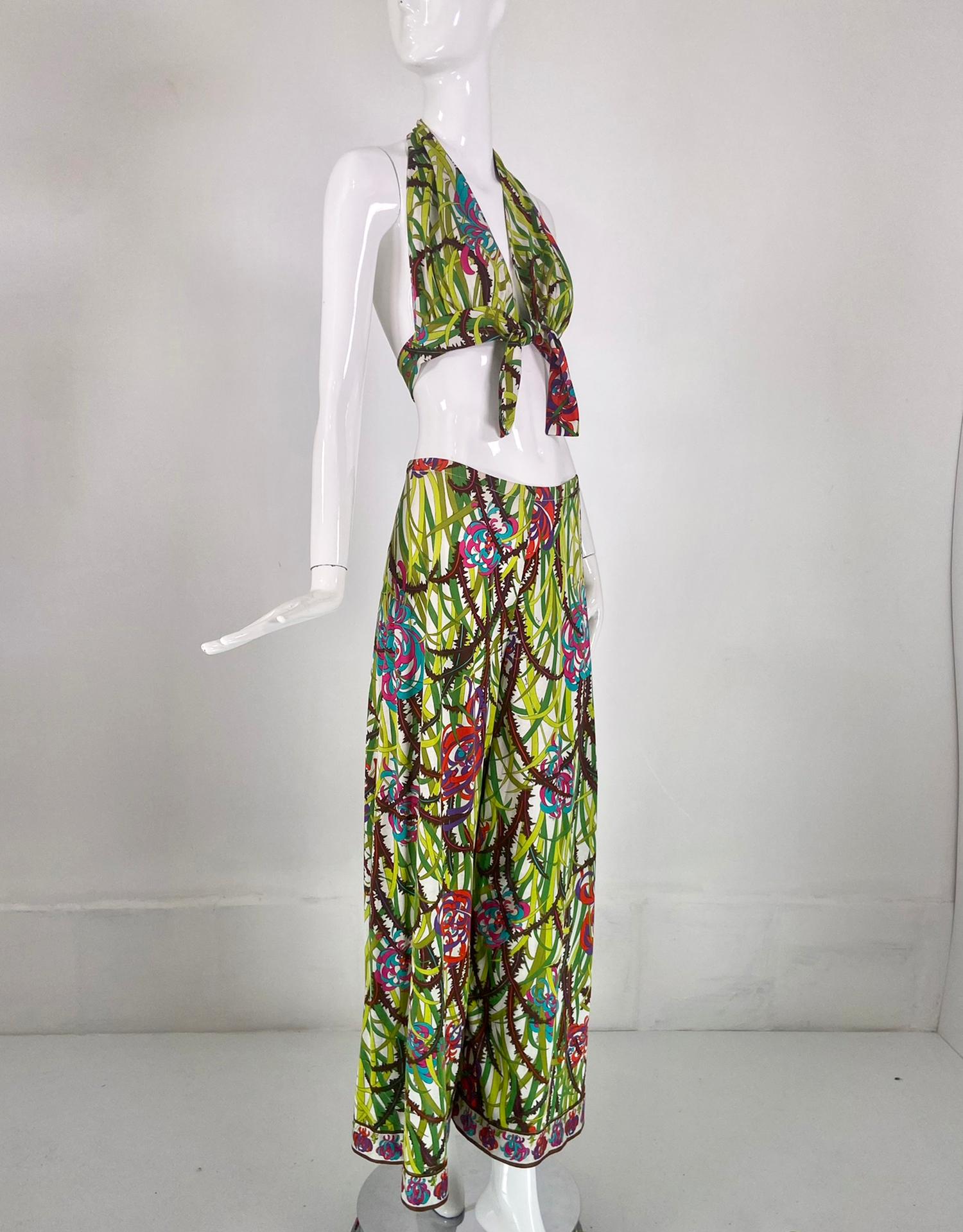 Pantalone palazzo in jersey di cotone stampato di Emilio Pucci e reggiseno con laccetti, pigiama da spiaggia datato 15/04/1975. Il top con reggiseno a collo alto si allaccia sul davanti, il pantalone coordinato si appoggia sui fianchi, le gambe sono
