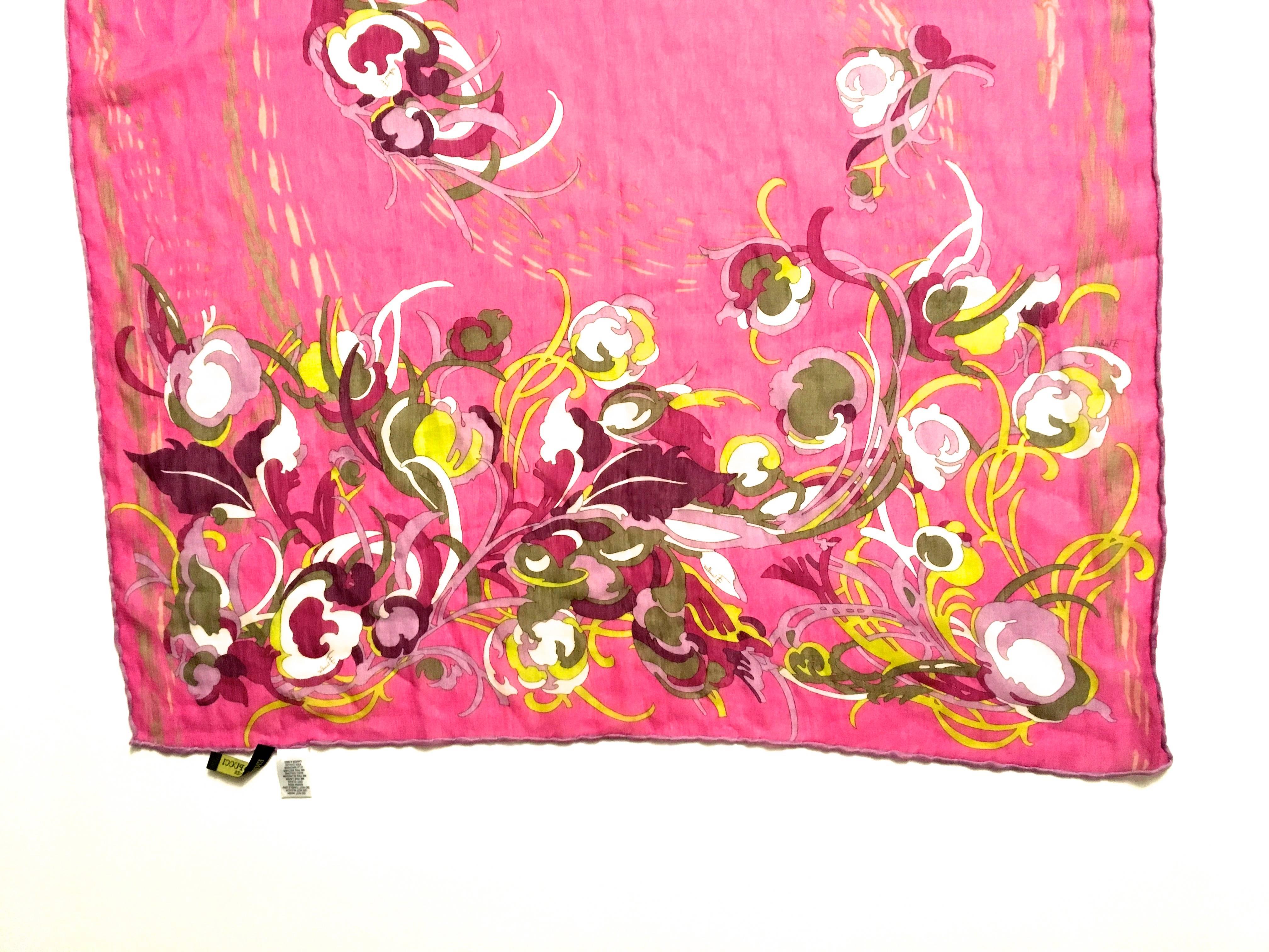 Presented here is a beautiful scarf from Emilio Pucci. This silk muslin scarf has a floral design with a pink backdrop. The flowers are colors of yellow, green, white, red and pink. The scarf is signed in the body of the design by Emilio Pucci.