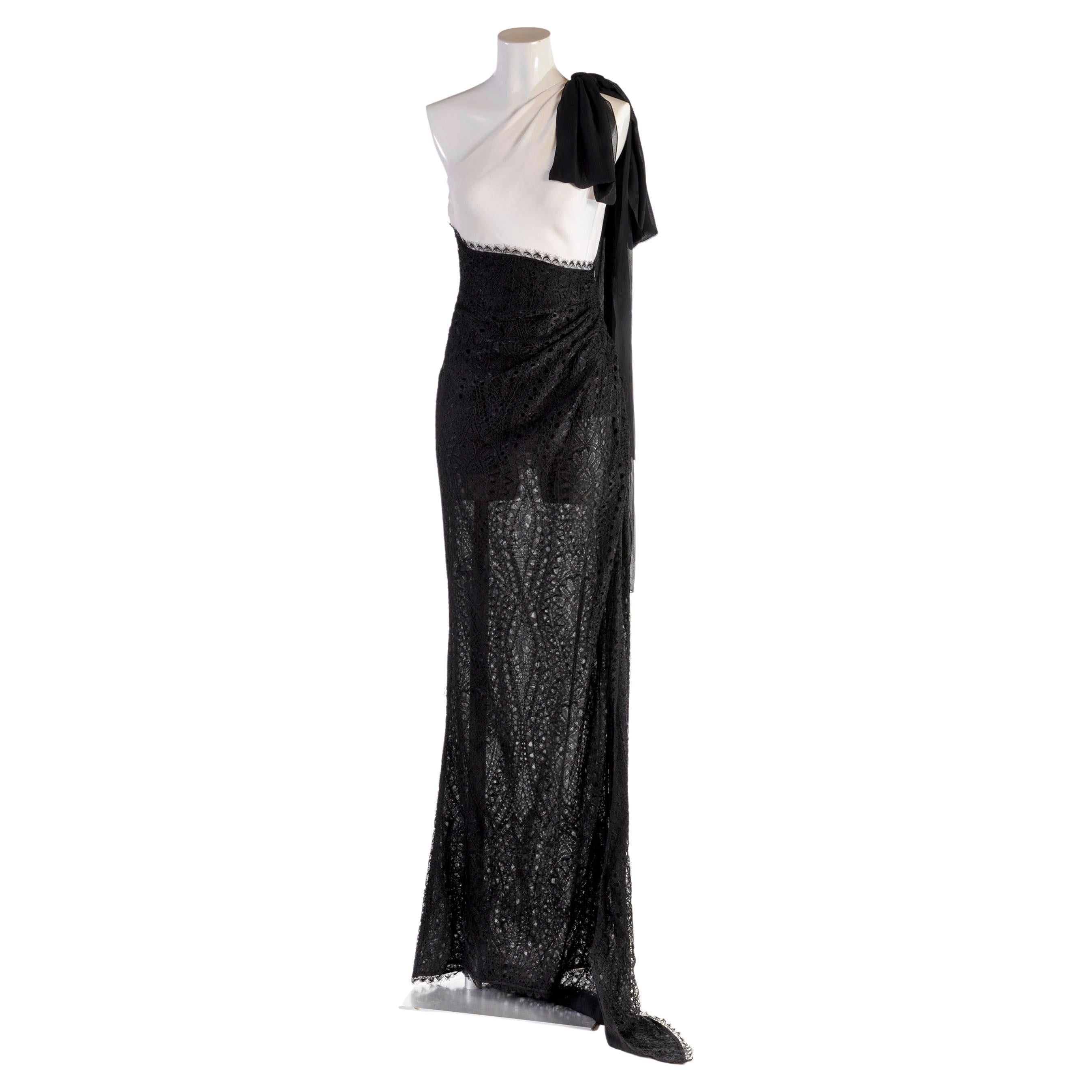 EMILIO PUCCI
Long one-shoulder dress in white silk and black lace with short tail
Deep left side slit
Black bow in silk on the left shoulder
Draping on the hips
Side zip
Size IT 42
Made in Italy
Fabric:
47% silk
40% rayon
13% polyamide
Lace:
55%