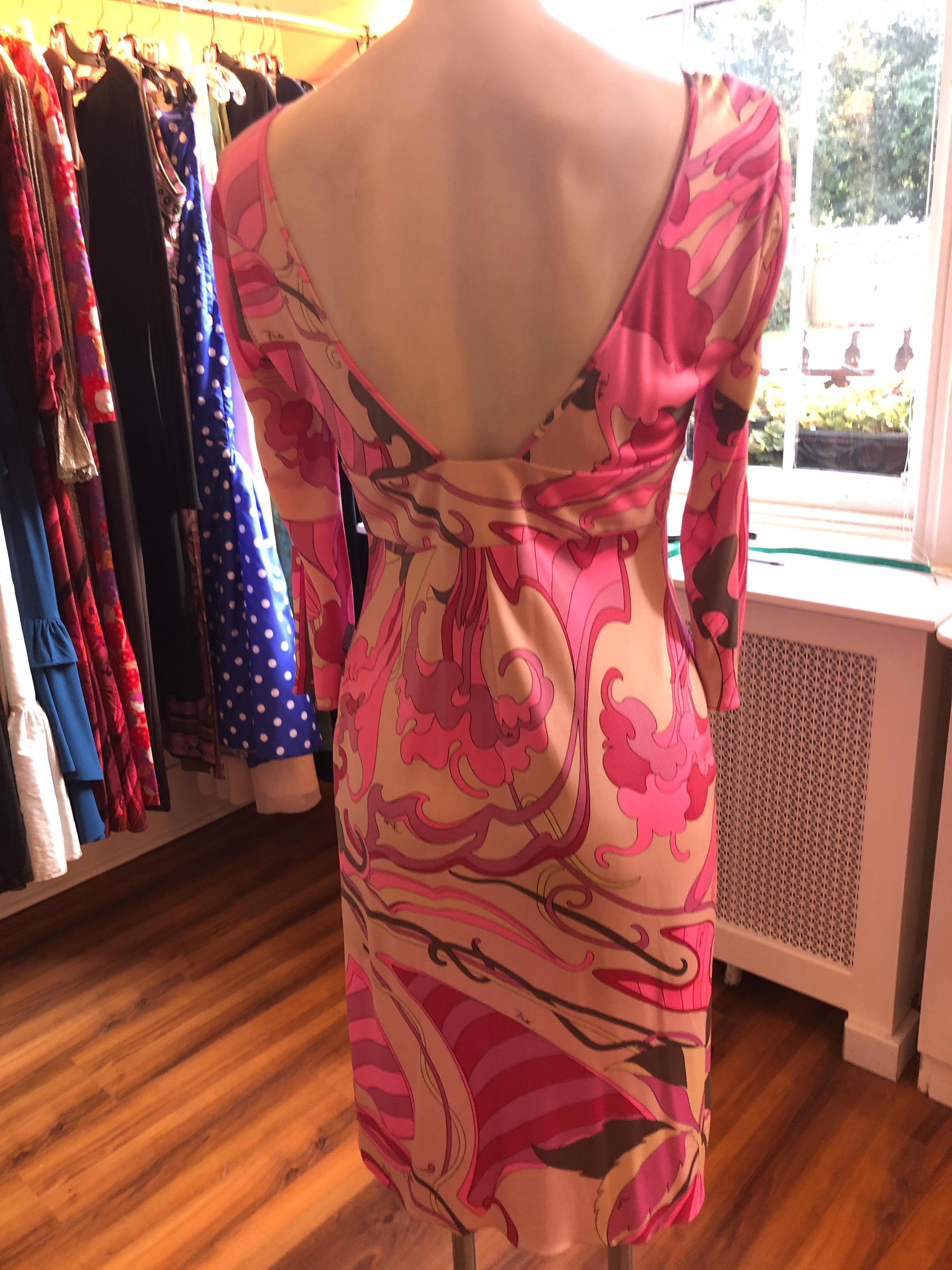 Nice combination of a V-neck top with a band under the bust and a v/u shaped back. This silk dress has an abstract floral patter with the predominant colors being pink, purple with a cream background and dashes of soft yellow and grey.