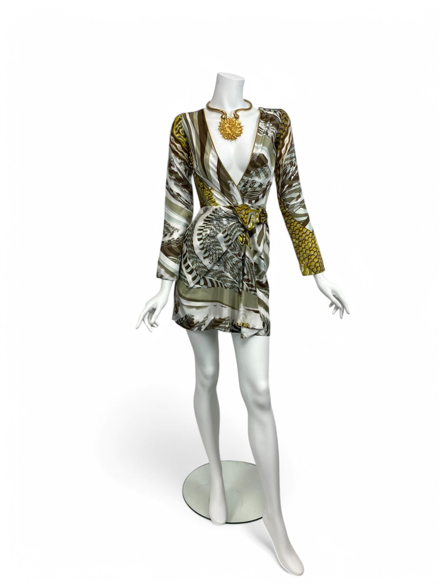 This striking mini dress from Emilio Pucci captures the house’s signature blend of bold sensuality and refined tailoring. Crafted from luxurious silk, the design features a daring plunging neckline that contrasts with long sleeves and a sleek