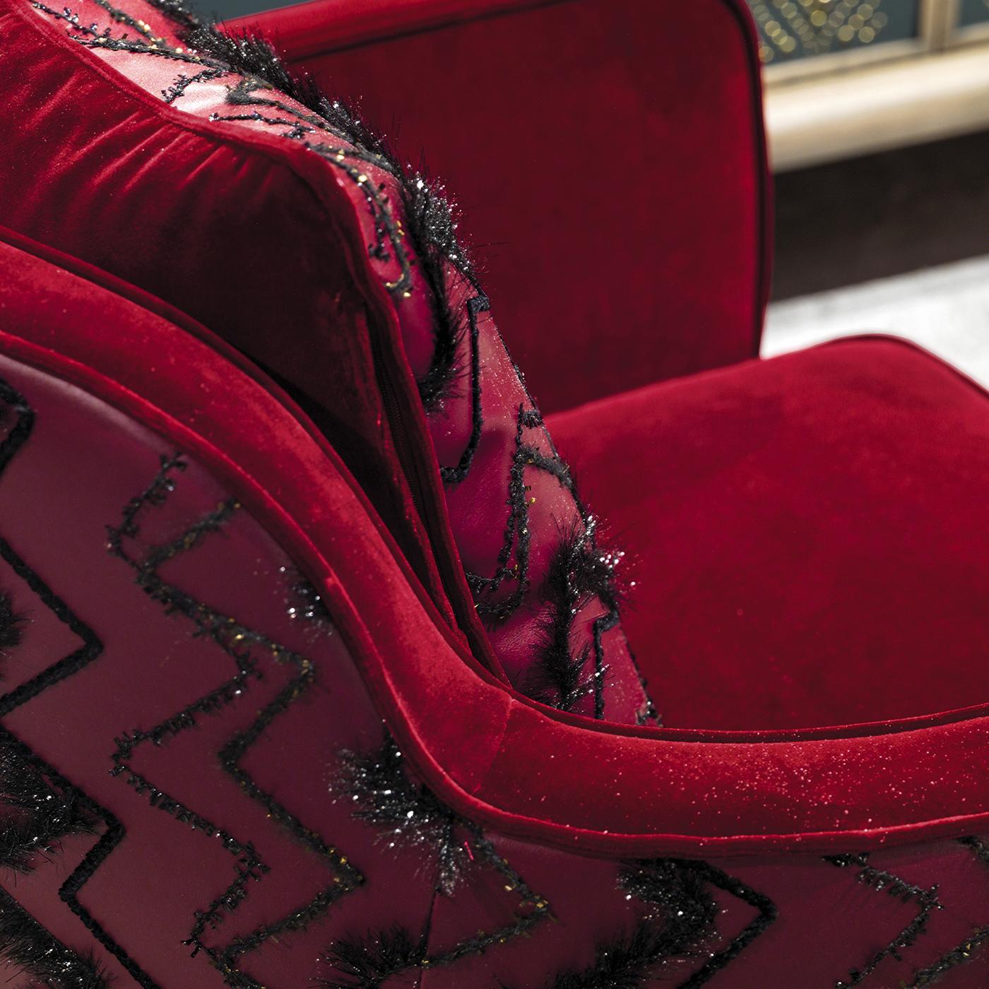 As if straight from a glamorous lounge, the Emily armchair exudes luxury where minimalism just won't do. On a bronze-colored base, the chair is upholstered in dramatic red cotton velvet and faux leather, then accented with zig-zag stitching. A