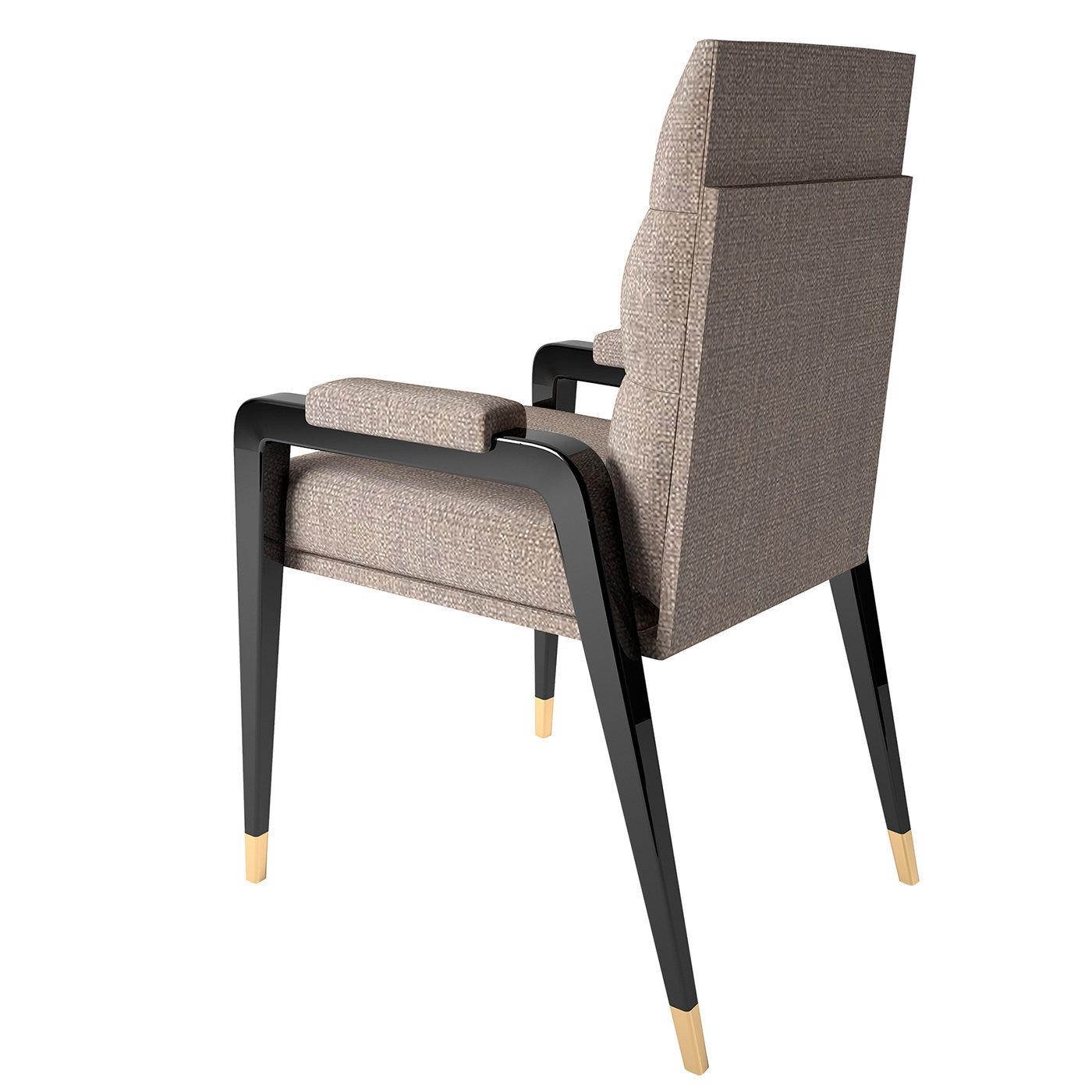 A clean and elegant design of refined sophistication, this chair by Giannella Ventura will infuse any modern interior with a timeless charm. Resting on a shiny black structure enriched with polished brass details, it features a gray