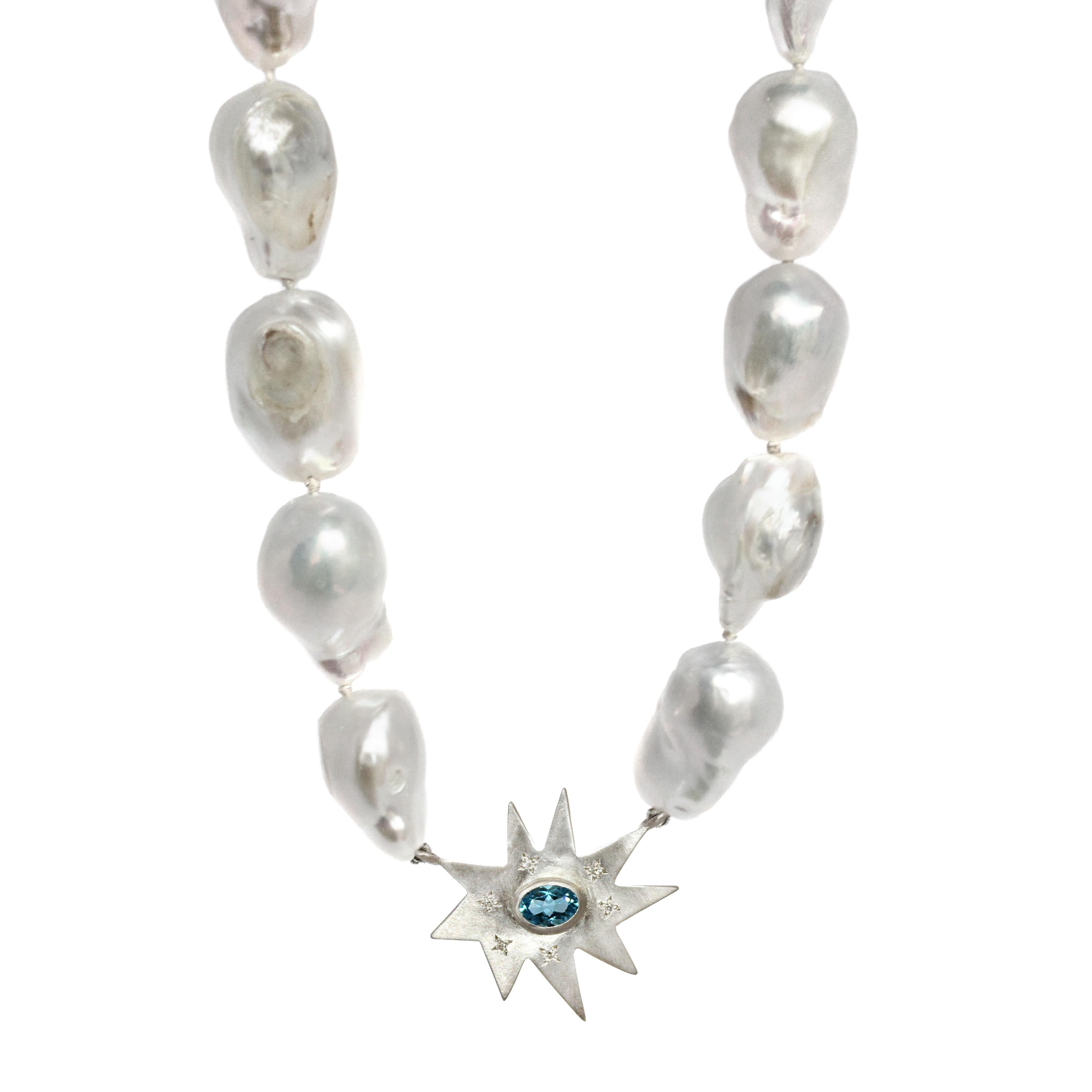 Our classic Stella star topped with diamonds is the home to a vibrant blue topaz center and framed perfectly against a strand of white baroque pearls. This necklace is full of natural beauty. Also pictured in gray/peacock pearls with peridot center