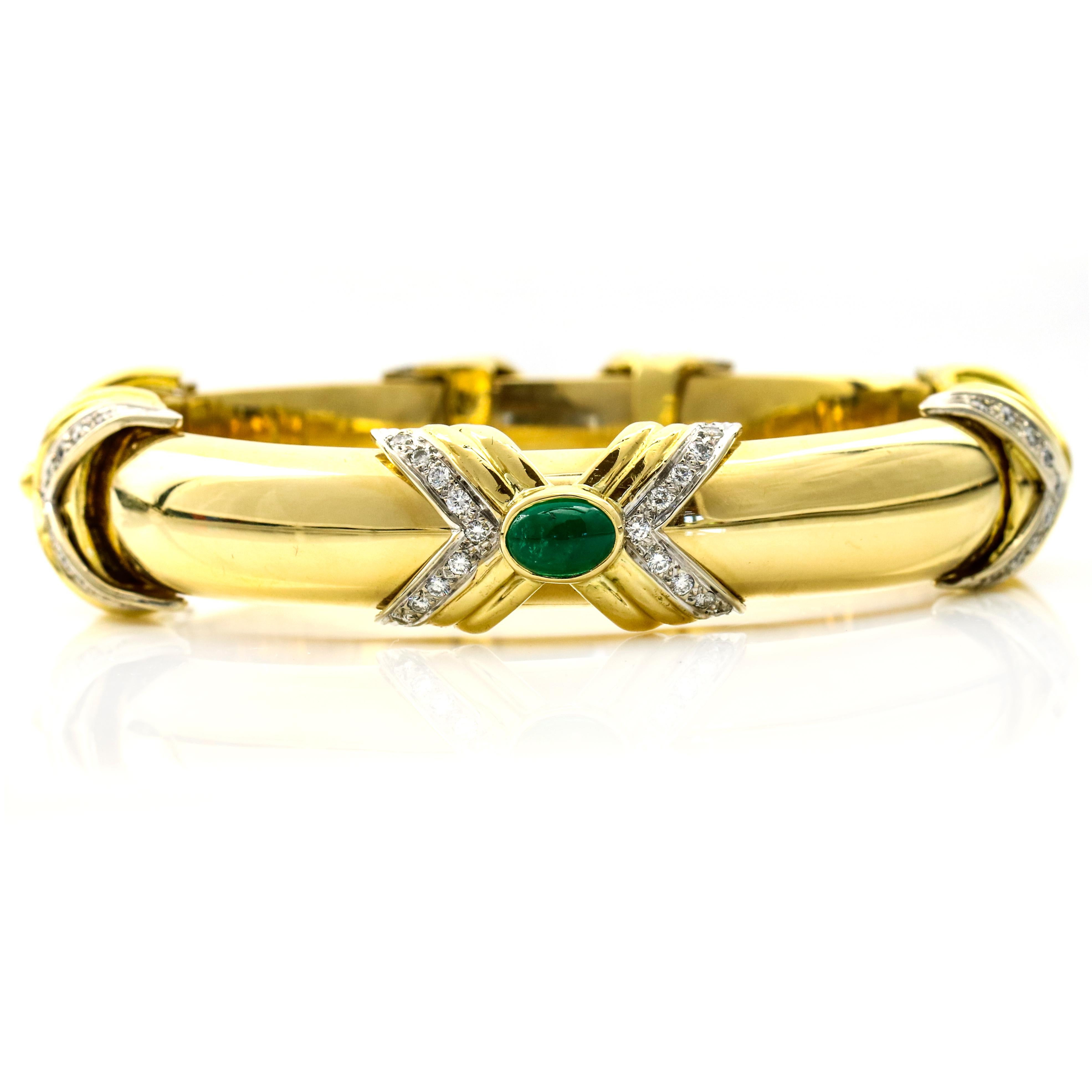 Emis Beros bangle bracelet in 18-karat yellow gold with emeralds and diamonds. The bracelet has 4 X stations, each with a bezel set cabochon cut emerald at center, and numerous round-cut diamonds on the X edges. Hinge opening. Slide clasp. 

Size,