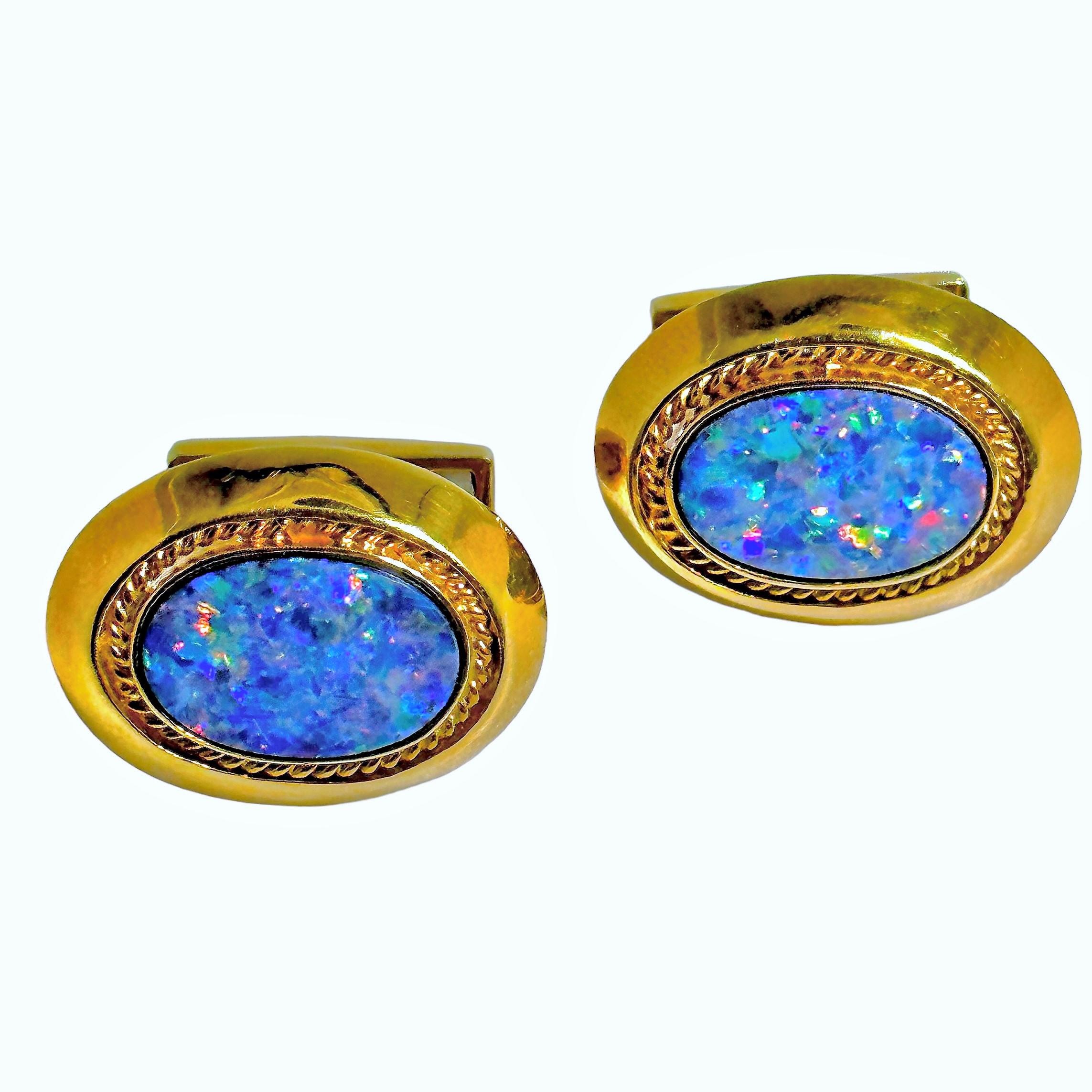 This pair of 18K yellow gold and black opal slab cuff links are absolutely luxurious. Each cuff link measures 1 inch by 3/4 inches and is set with one thin black opal slab, edged with raised rope motif. The pair are stamped 18K and EMIS for the