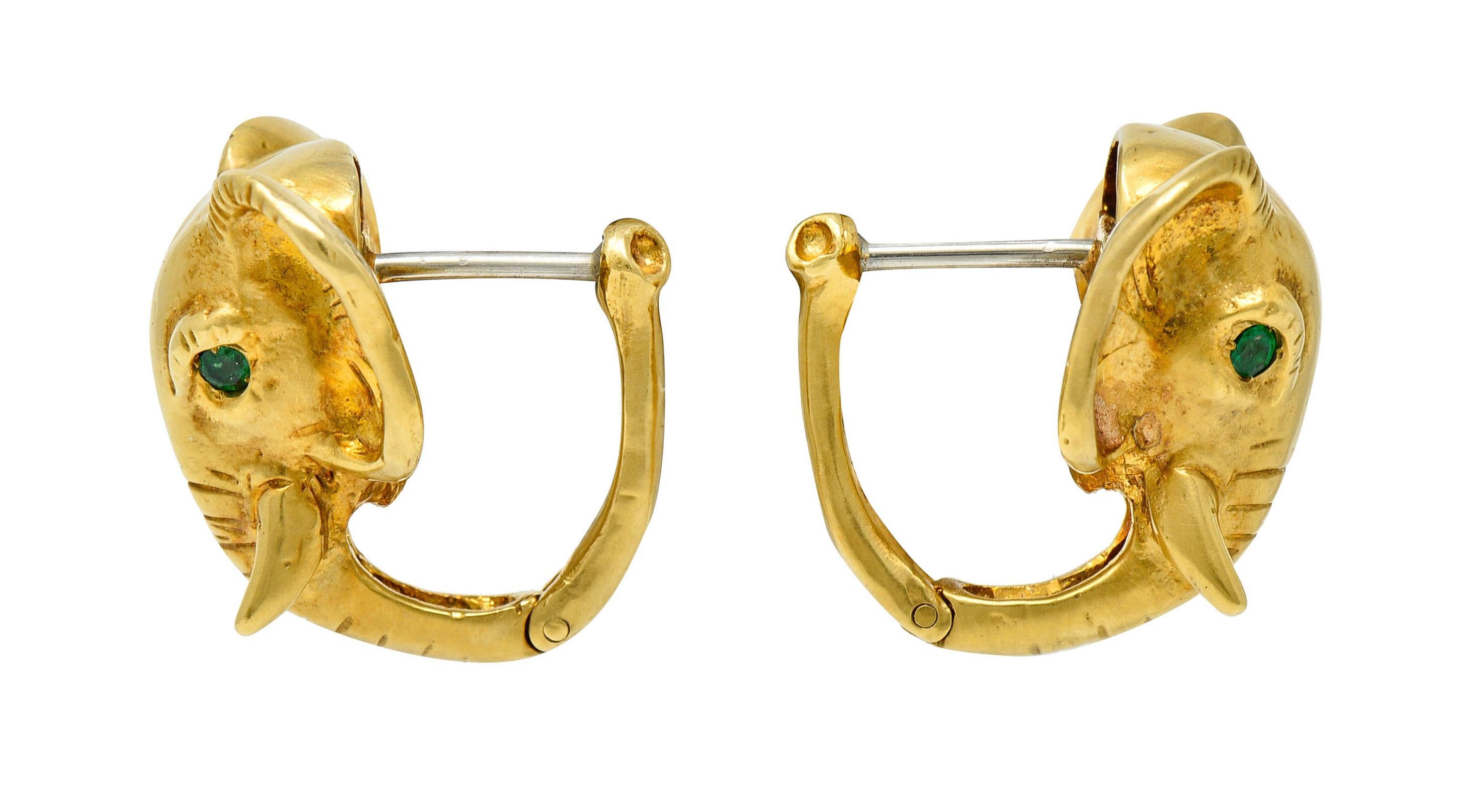 Hoop style earrings are designed as highly rendered African elephants

With deep wrinkle details and a fine juxtaposition between a high polish and a satin finish

Eyes are bright green round cut emeralds weighing in total approximately 0.20