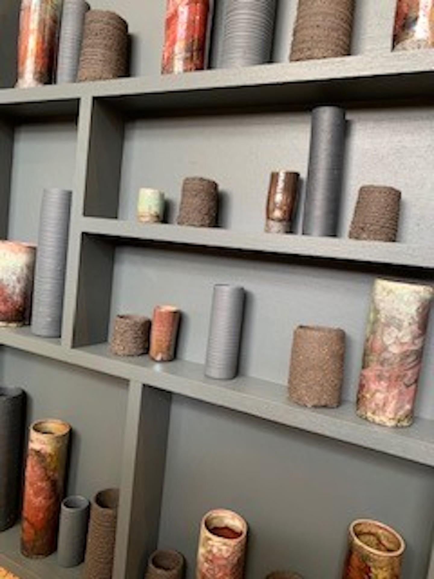 Emma Bell
Dark clays I
H70cm x w49cm x 7cm
Emma Bell’s ceramic and porcelain Pot Frame – Installation Piece.
Emma Bell says: “This piece is inspired by my glaze test vessels. As a potter, I am always staggered by how different the same/similar glaze