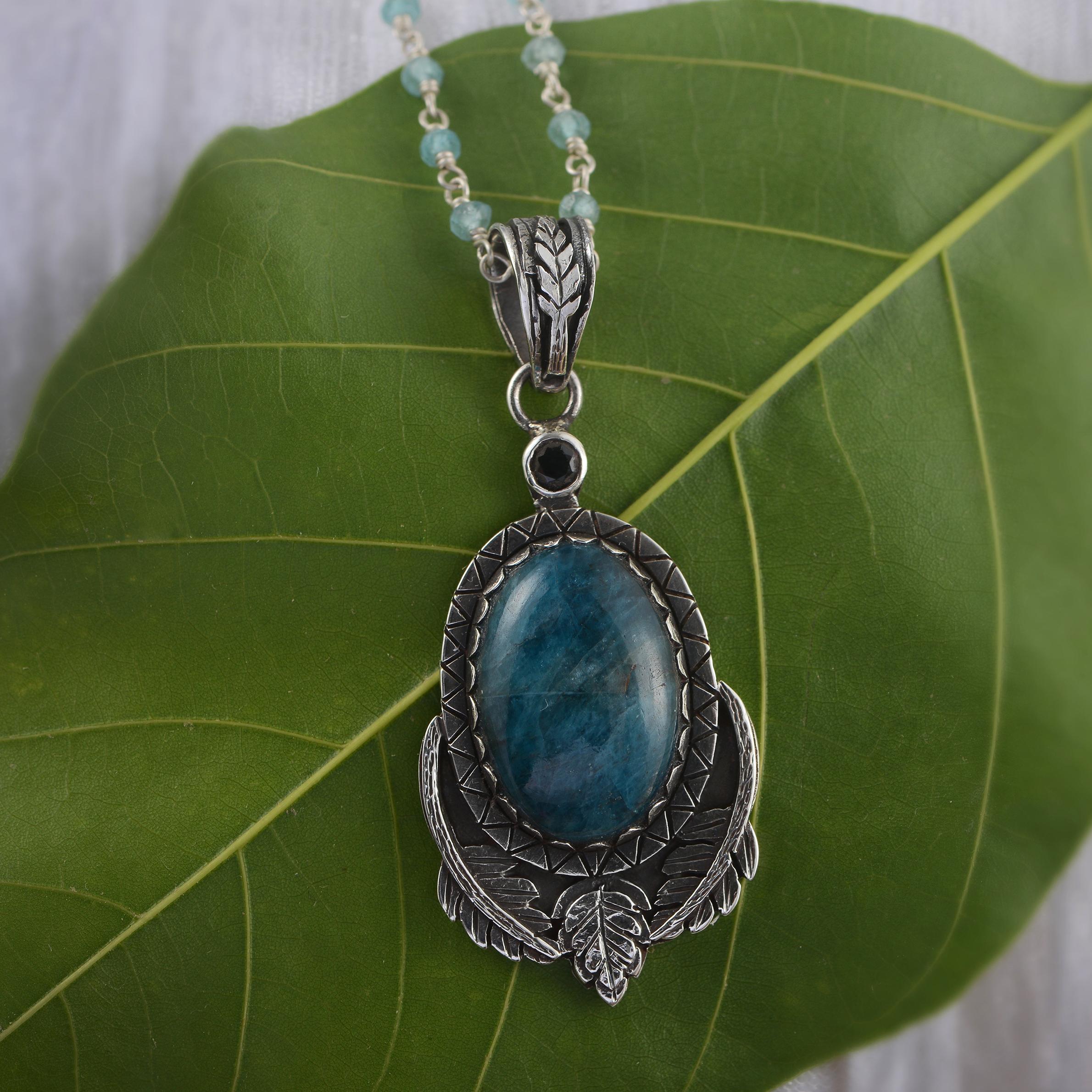 This lovely one of a kind  Apatite Sapphire Silver Pendant has been handmade in our workshops.

It features a large cabochon apatite which is capped with a blue sapphire. The pendant is made of oxidized sterling silver which has been hand engraved