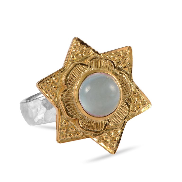 

This striking Aquamarine Gold Plate Statement Ring, has been handmade in our workshops. It features a central cabochon aquamarine which is surrounded by intricate hand engraving work. The ring is made in sterling silver coated with 24kt gold