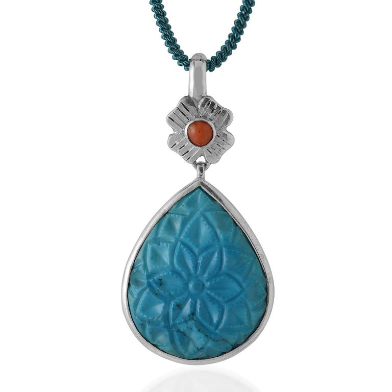 This exquisite Emma Chapman Coral Turquoise Carved Silver Pendant,  has been handmade in our workshops. It has a turquoise drop which has been hand carved and is capped with a floral motif which is hand engraved and embedded with a coral. The
