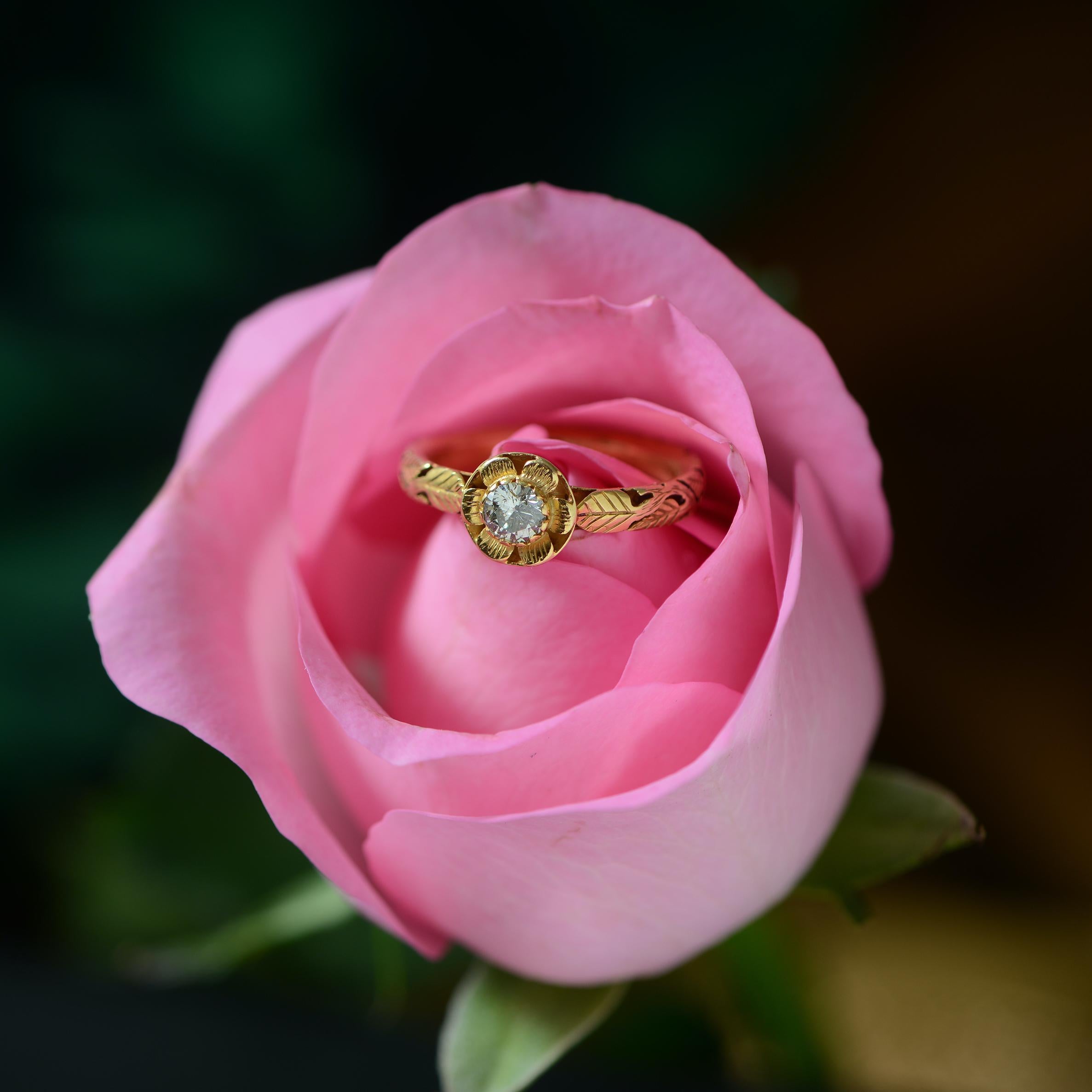 This adorable one of a kind ring Emma Chapman Diamond 18 Karat  Gold Engagement Ring, has been handmade in our workshops. It has a central full cut diamond set in 18k gold. The ring has exquisite hand engraving work on it using floral motifs as has