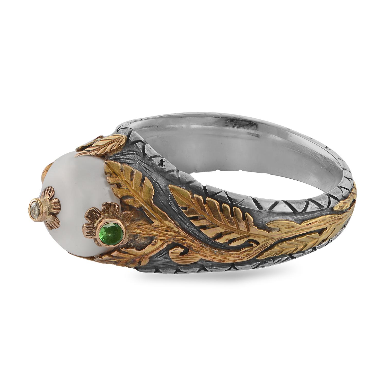 This exquisite one of a kind Emma Chapman Pearl Diamond Tsavorite 18kt Gold Ring, has been handmade in our workshops. It features a  central pearl which is embedded with a full cut diamond set in an 18kt gold flower. The pearl is flanked by two