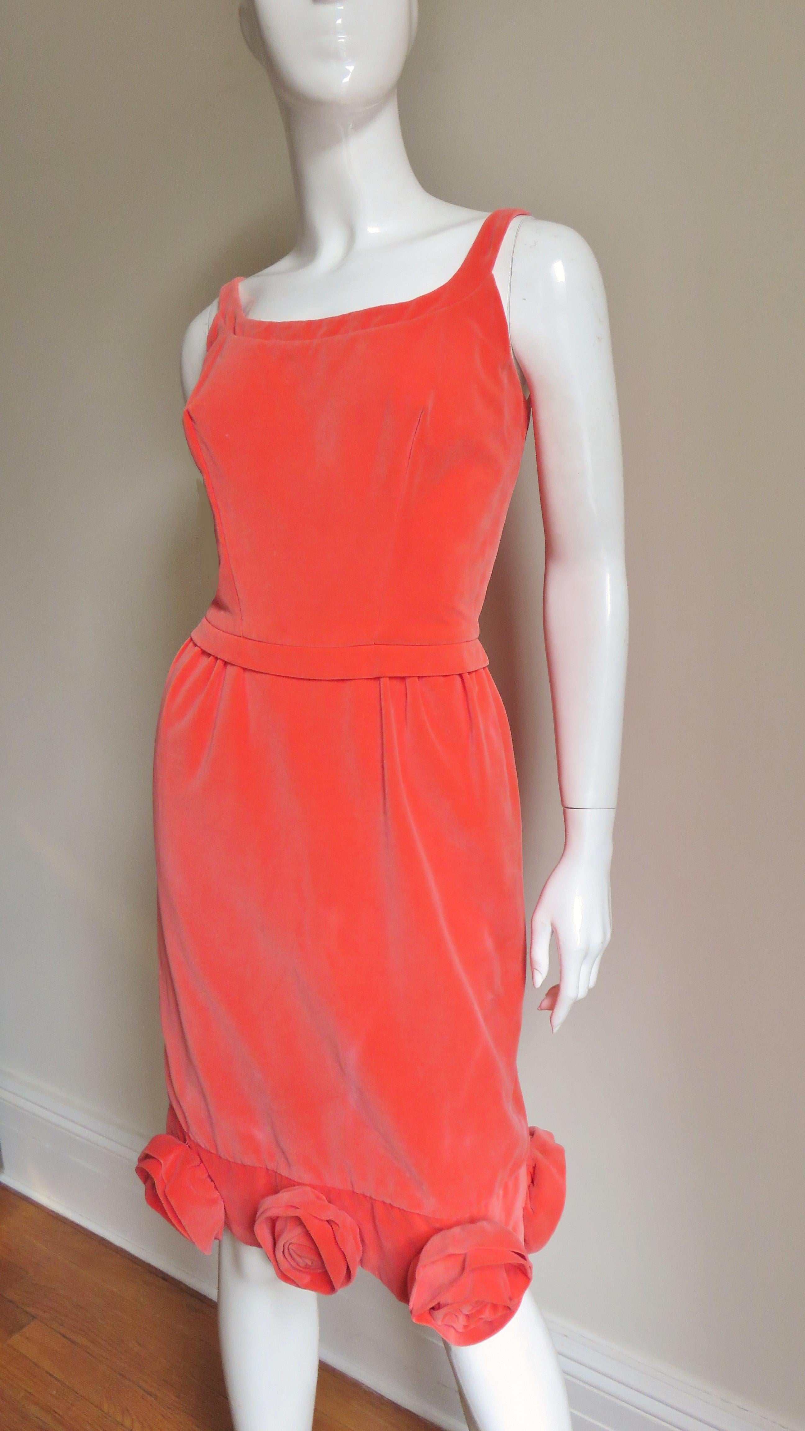 A great coral velvet dress from Emma Domb.  It has a scoop neckline, shoulder straps and a small band at the waist. The straight skirt portion is encircled around the hem with 7 applique roses.  It is fully lined and has a center back metal