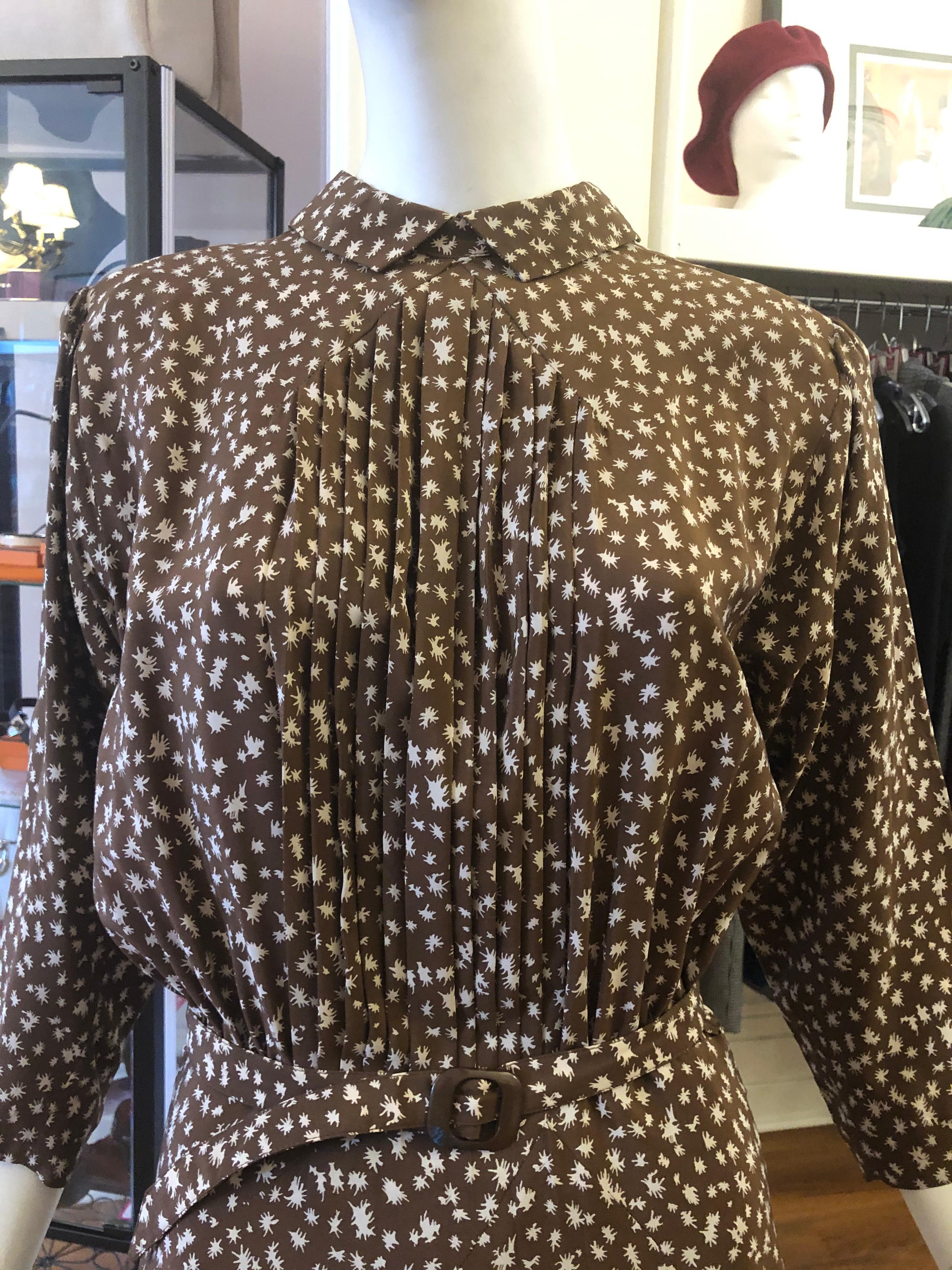 Cette jolie robe a un fond marron avec un imprimé blanc 