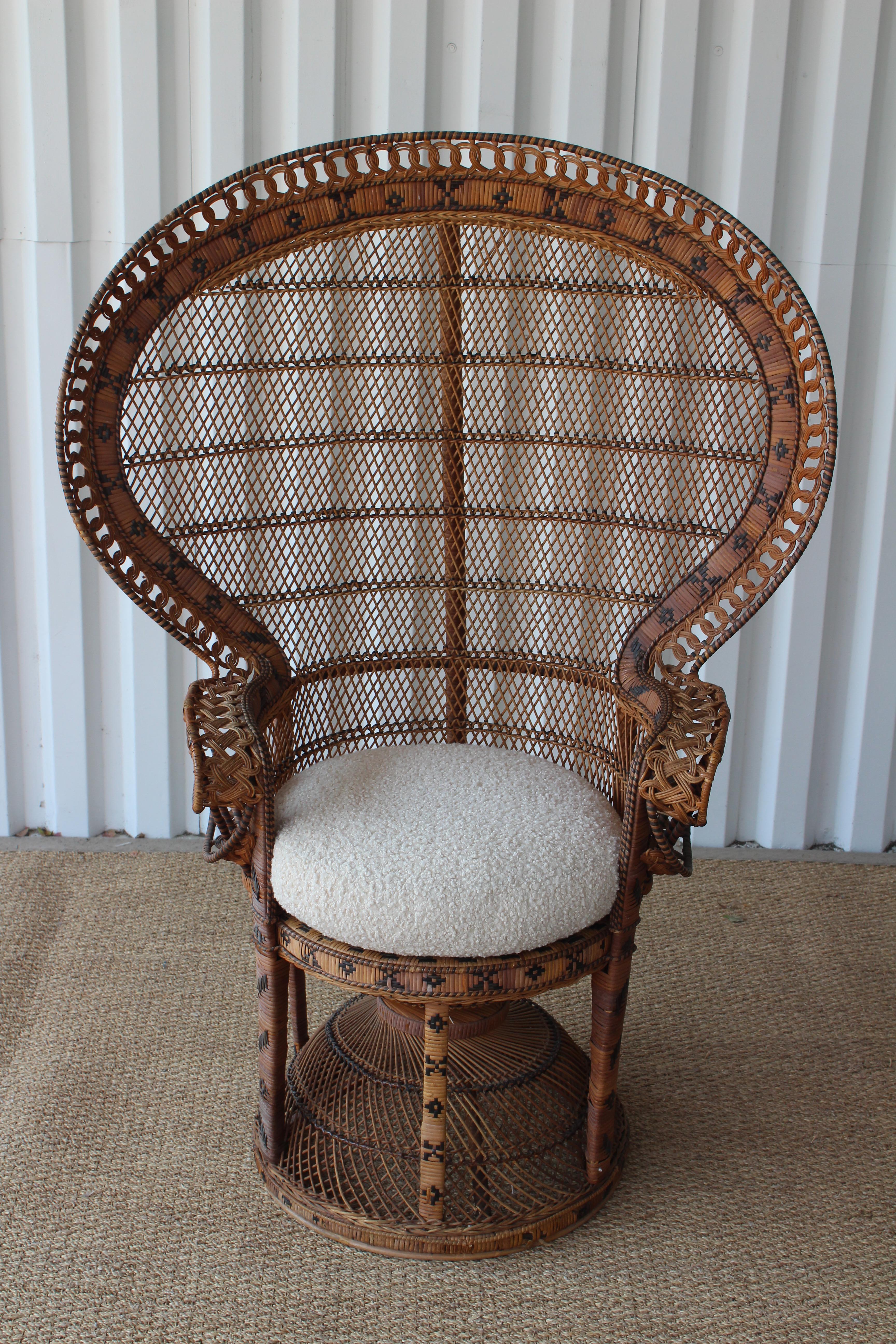 Vintage Emmanuelle wicker and rattan peacock chair, made my Kok Maison in the 1970s. In overall good condition. New wool curly shearling-like upholstered cushion. The top right edge of the chair has some wicker banding that has separated from the