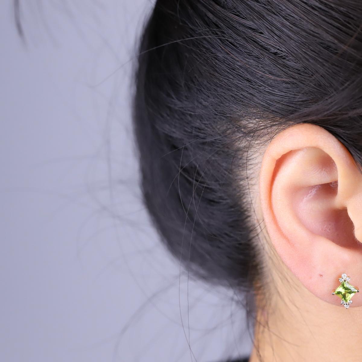 Decorate yourself in elegance with this Earrings is crafted from 10-karat Yellow Gold by Gin & Grace. This Earrings is made up of Square-cut Peridot (2 pcs) 1.42 carat and Round-cut White Diamond (12 Pcs) 0.11 Carat. This Earrings is weight 1.24