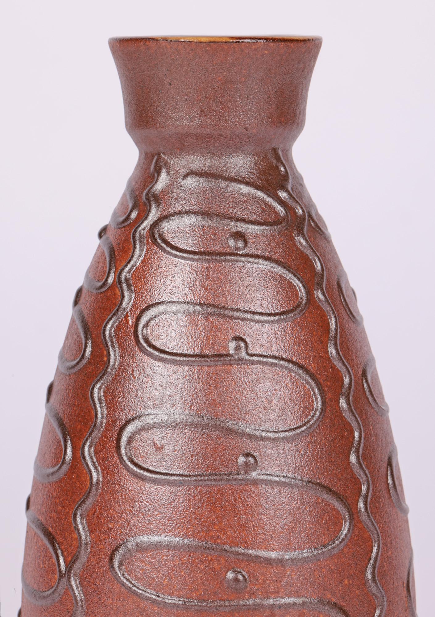 A personal favorite is this very stylish West German mid-century art pottery vase by Emons Söhne Keramik and probably dating around 1960. The finely made ceramic vase stands on a narrow round unglazed foot with slightly recessed base and is of tall