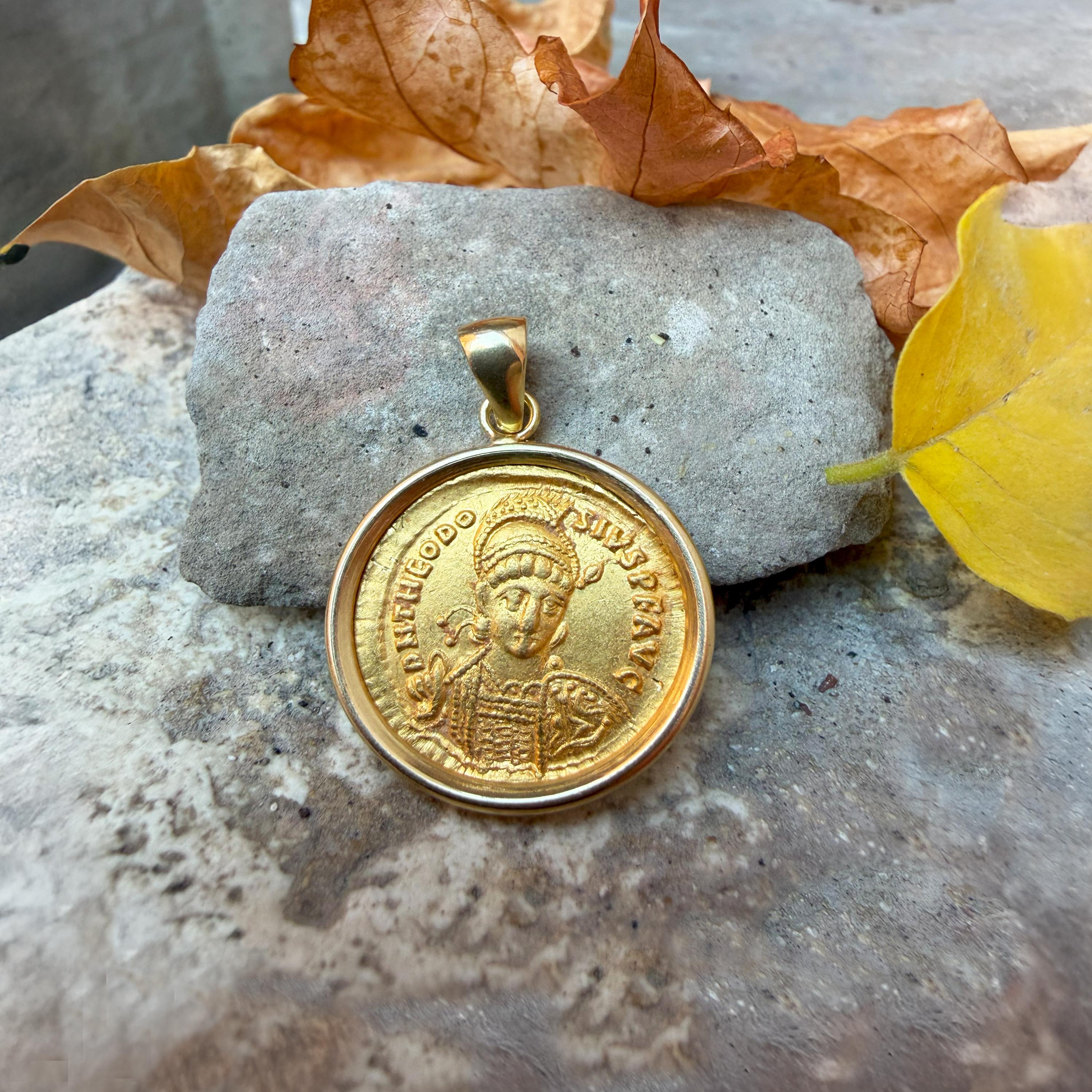 This magnificent 18 Kt gold pendant features an authentic Roman coin (solidus) in 24 Kt gold, dating back to the 5th century A.D. The coin depicts Emperor Theodosius II on one side and the personification of the city of Constantinople on the