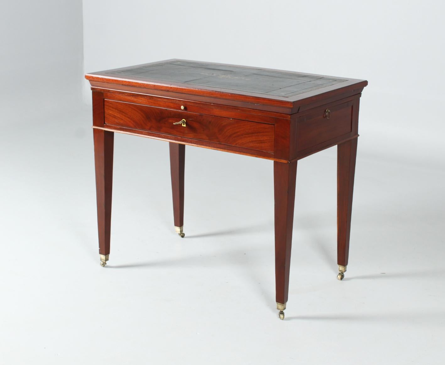 Antique architect table

France
mahogany, leather
Empire around 1810

Dimensions: H x W x D: 78 x 89 x 55 cm

Description:
Architect's or draftsman's table standing on pointed legs with brass casters. So-called 
