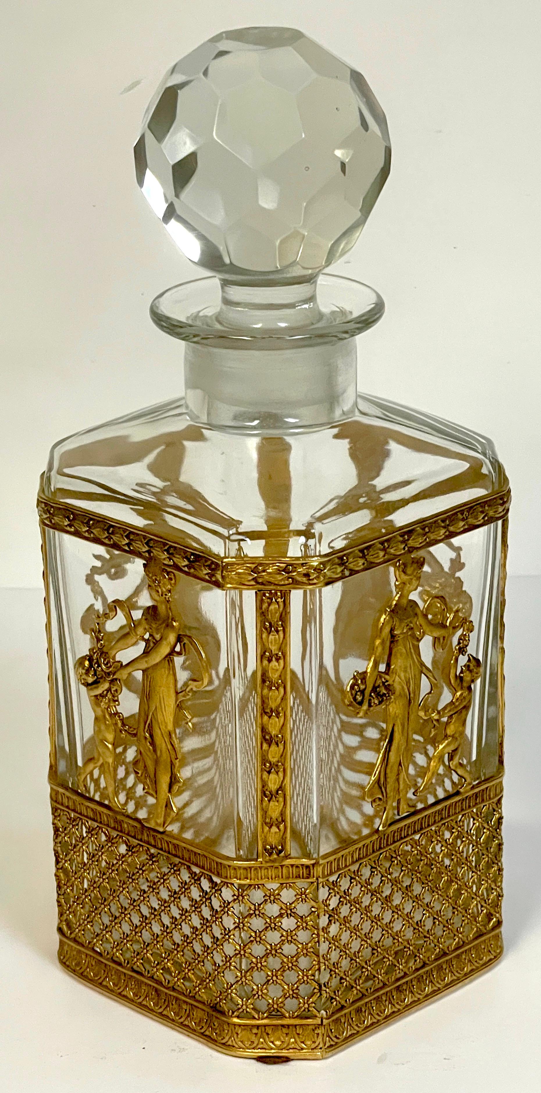 Carafe Empire de style Baccarat montée en ormolu, un exemple exquis, avec bouchon à facettes, la bouteille équipée d'une vignette classique allégorique à quatre panneaux finement moulée et dorée. D'une hauteur de 10 pouces et d'un diamètre carré de