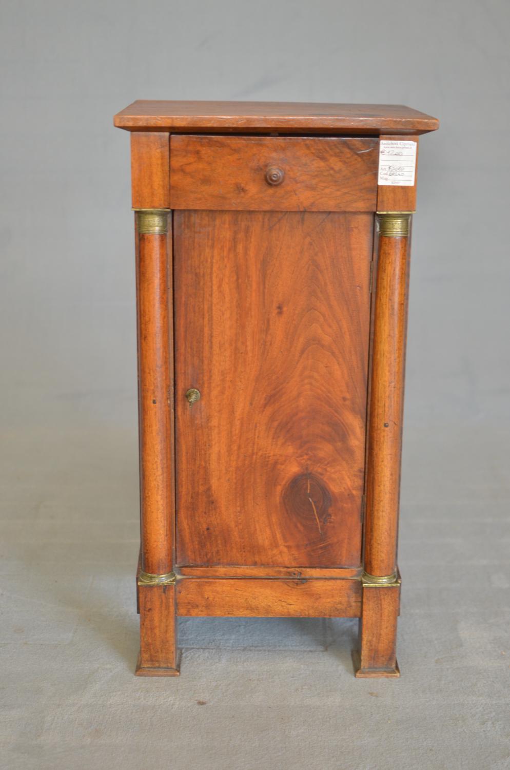 Empire bedside table in light walnut of French origin from 1840. The bedside table has an upper drawer and lower door. All the bronzes of the columns and the particular handle of the door are present.