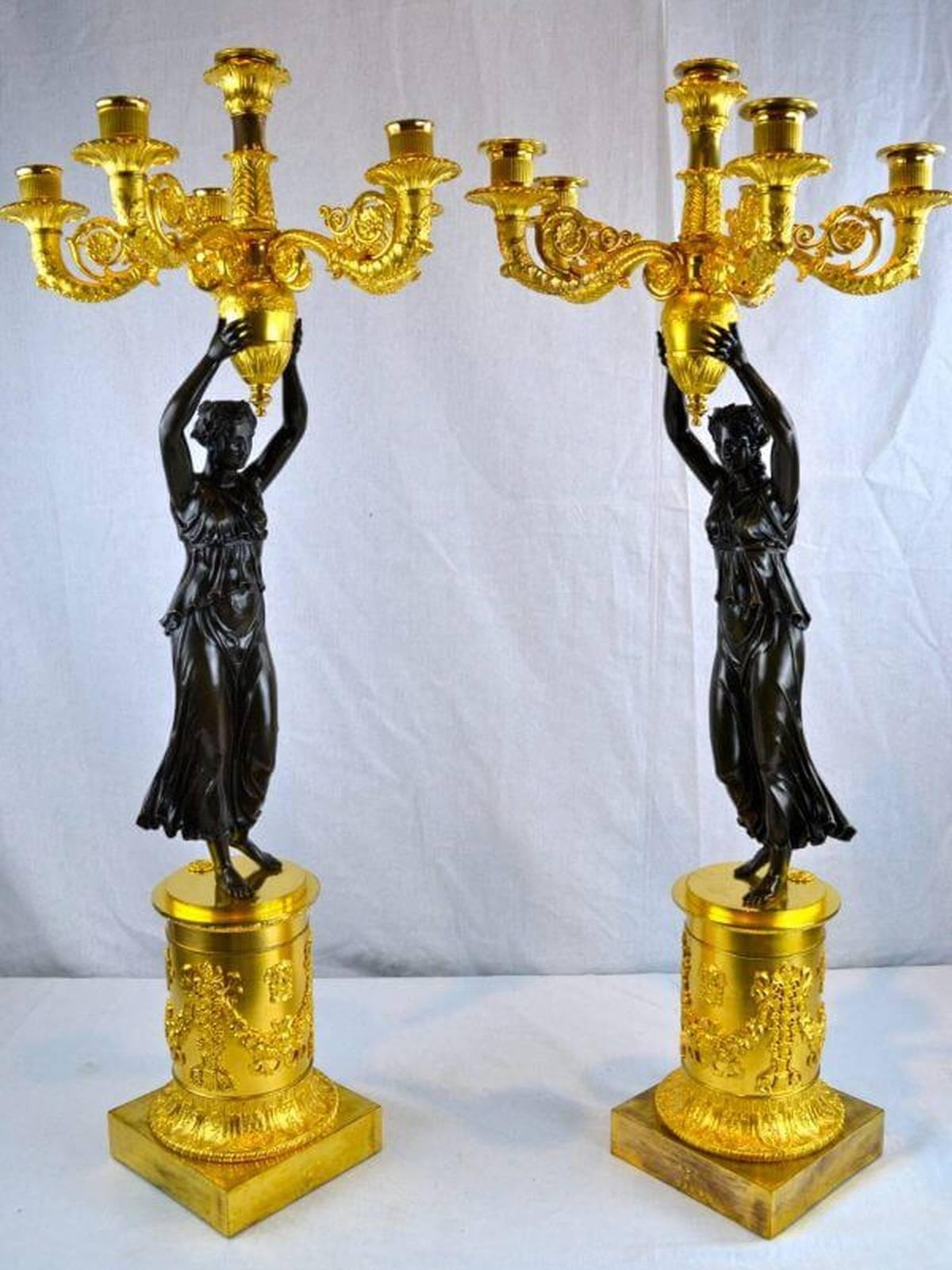 An important pair of period French Empire candelabra, the bases stamped with inventory marks from the Garde Meuble in Paris, (the repository of inventory from the French Royal collections as well as from major public institutions). A patinated