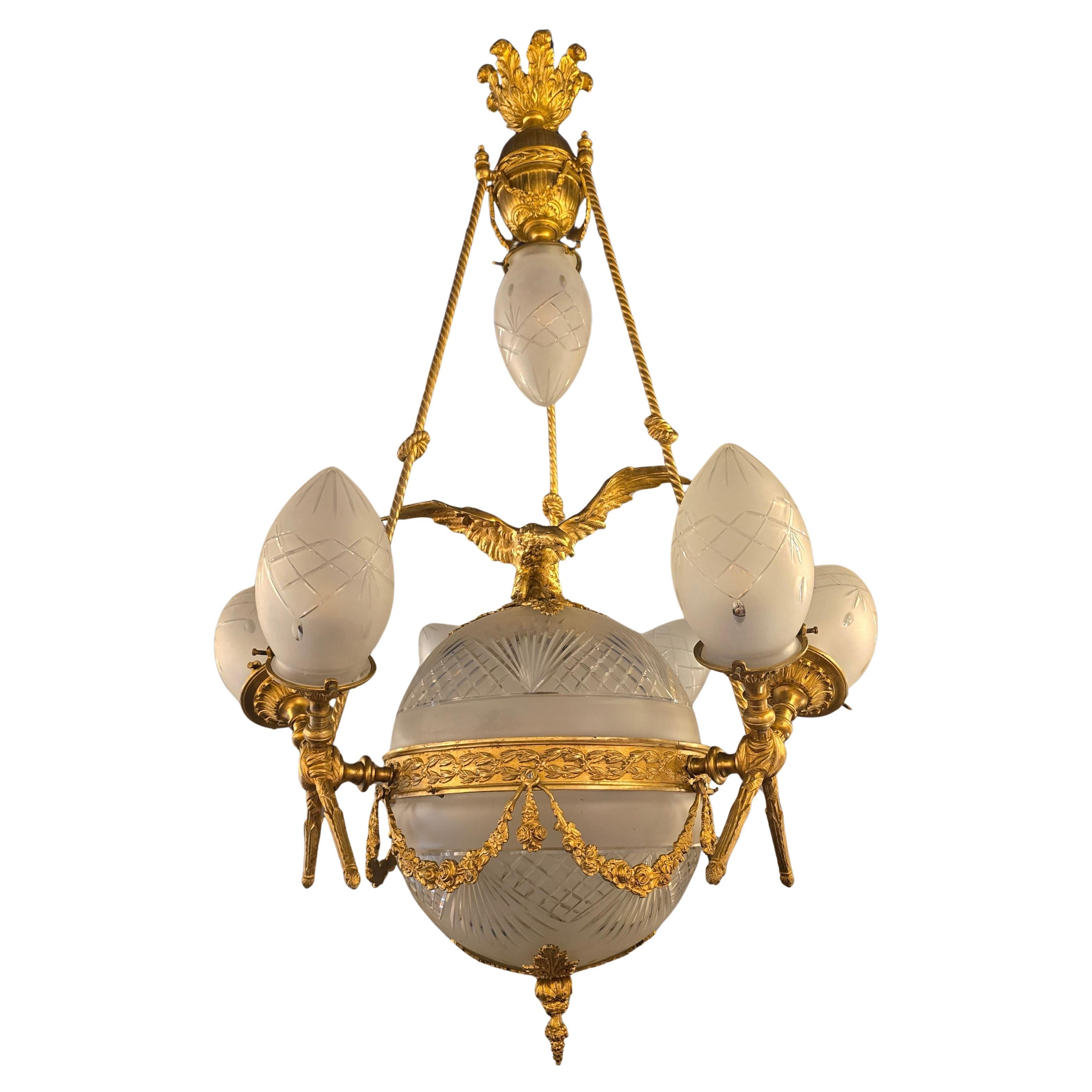 Gran Araña de Bronce y Cristal Estilo Imperio con Águila - Símbolo del Poder y de los Estados Unidos

Esta monumental araña de estilo Imperio está elaborada en bronce finamente dorado combinado con cristal tallado a mano y esmerilado. El globo